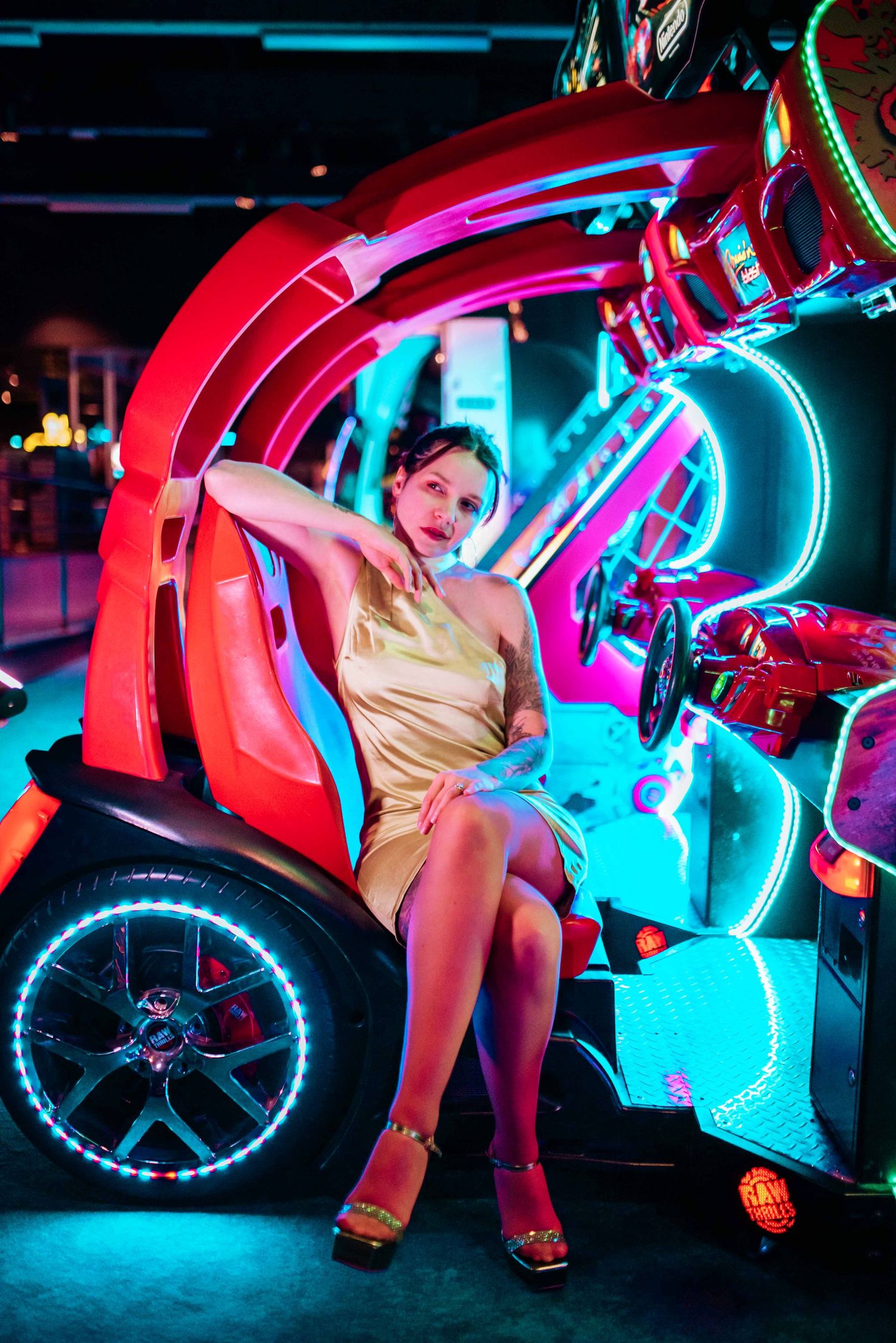Stylized arcade photography with neon blue and red lighting effects.