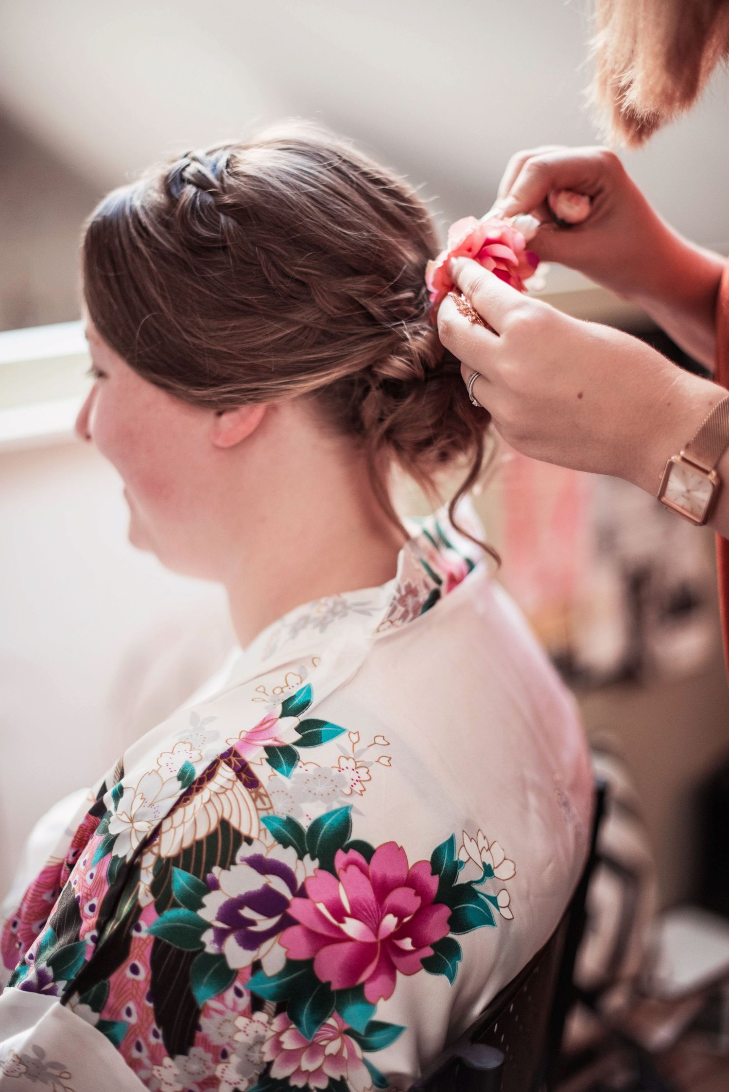Close-up detail of colorful floral robe being worn during wedding preparations.