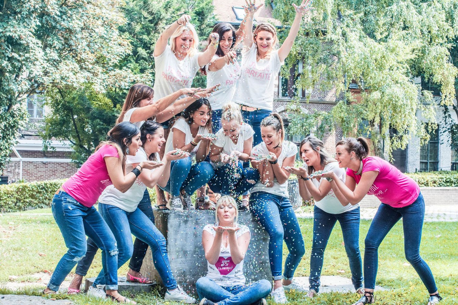 Friends striking dynamic poses in a line outdoors with trees in the background.