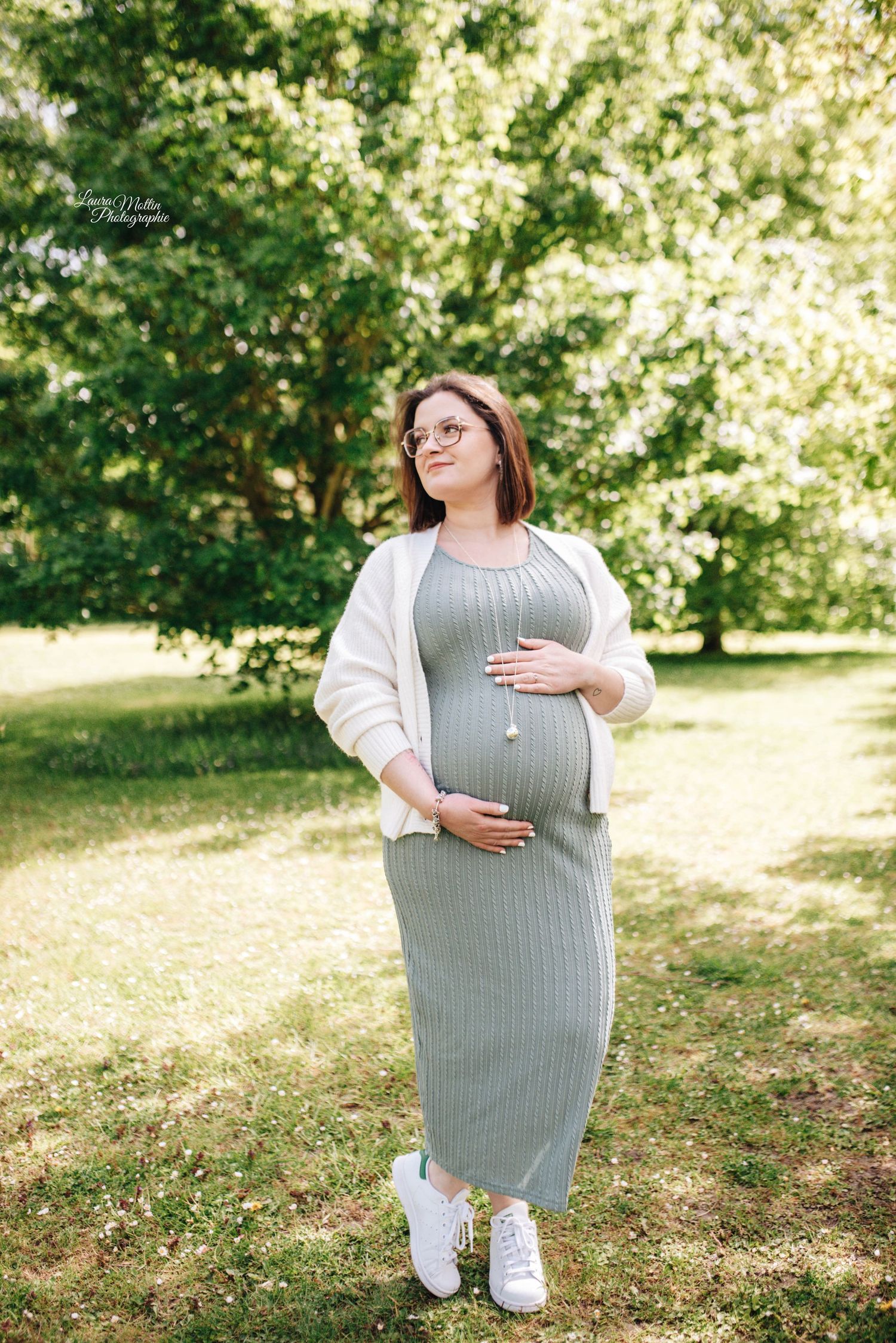 Outdoor maternity photos in a sunny garden setting with natural greenery.