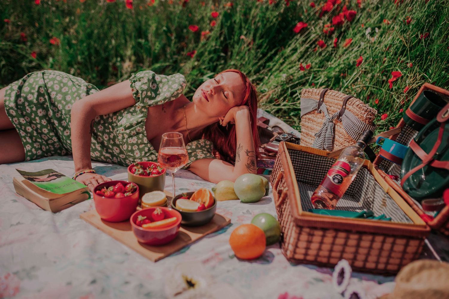 Fresh fruits and snacks laid out on a picnic blanket in a garden setting.