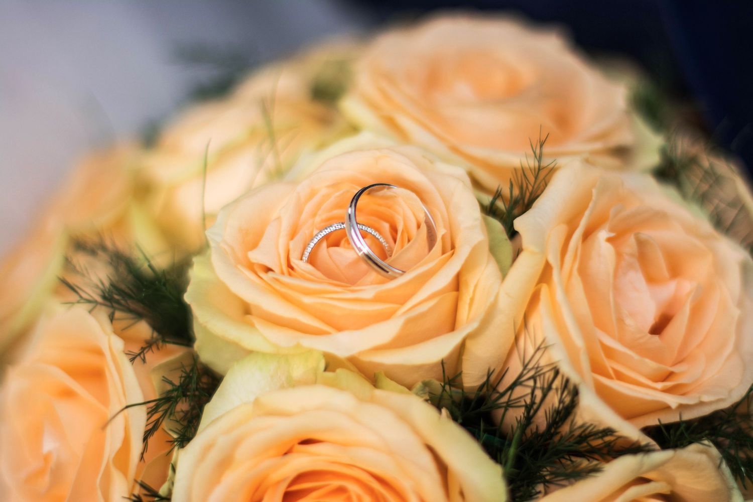 Close-up of peachy orange roses in a wedding bouquet arrangement.