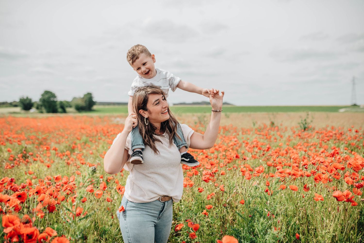Playful moments captured in a vibrant red poppy field on a sunny summer day.