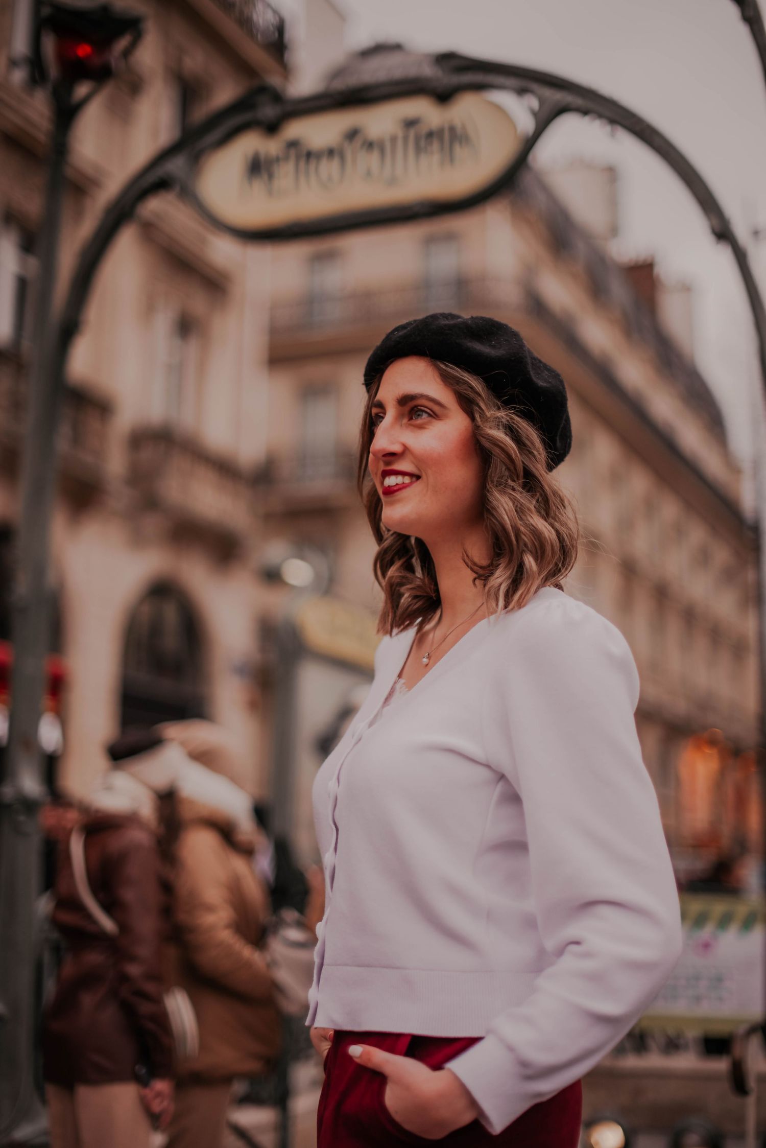 Street fashion photography in Paris with classic architecture in background.