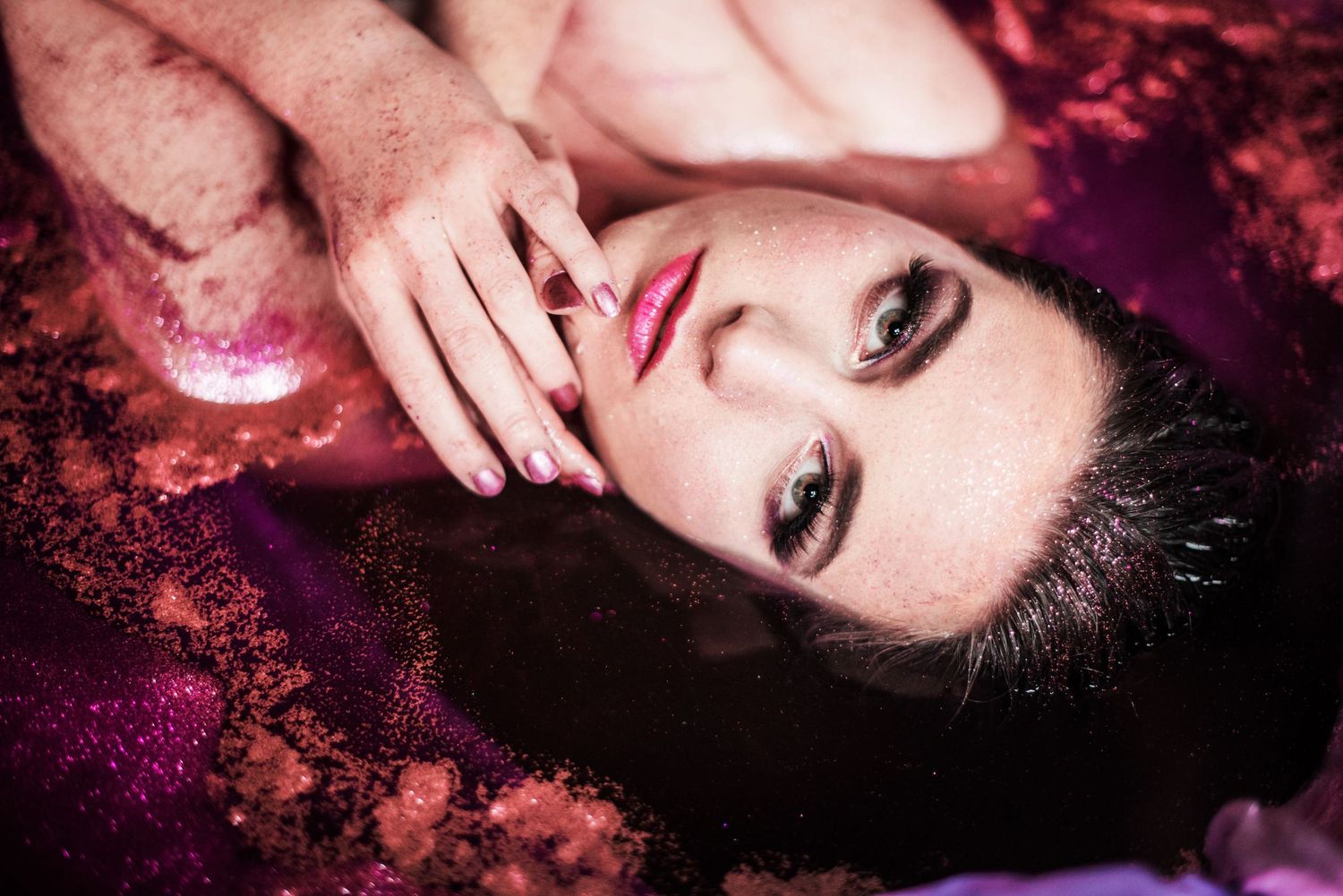 Artistic beauty portraits with pink sparkles and dramatic lighting effects.