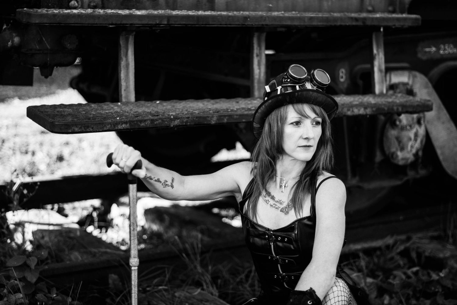 Moody black and white portraits against industrial backdrop.