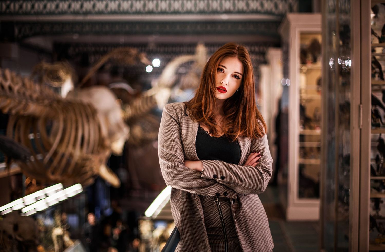 A dramatic portrait in a natural history museum with dinosaur exhibits visible.