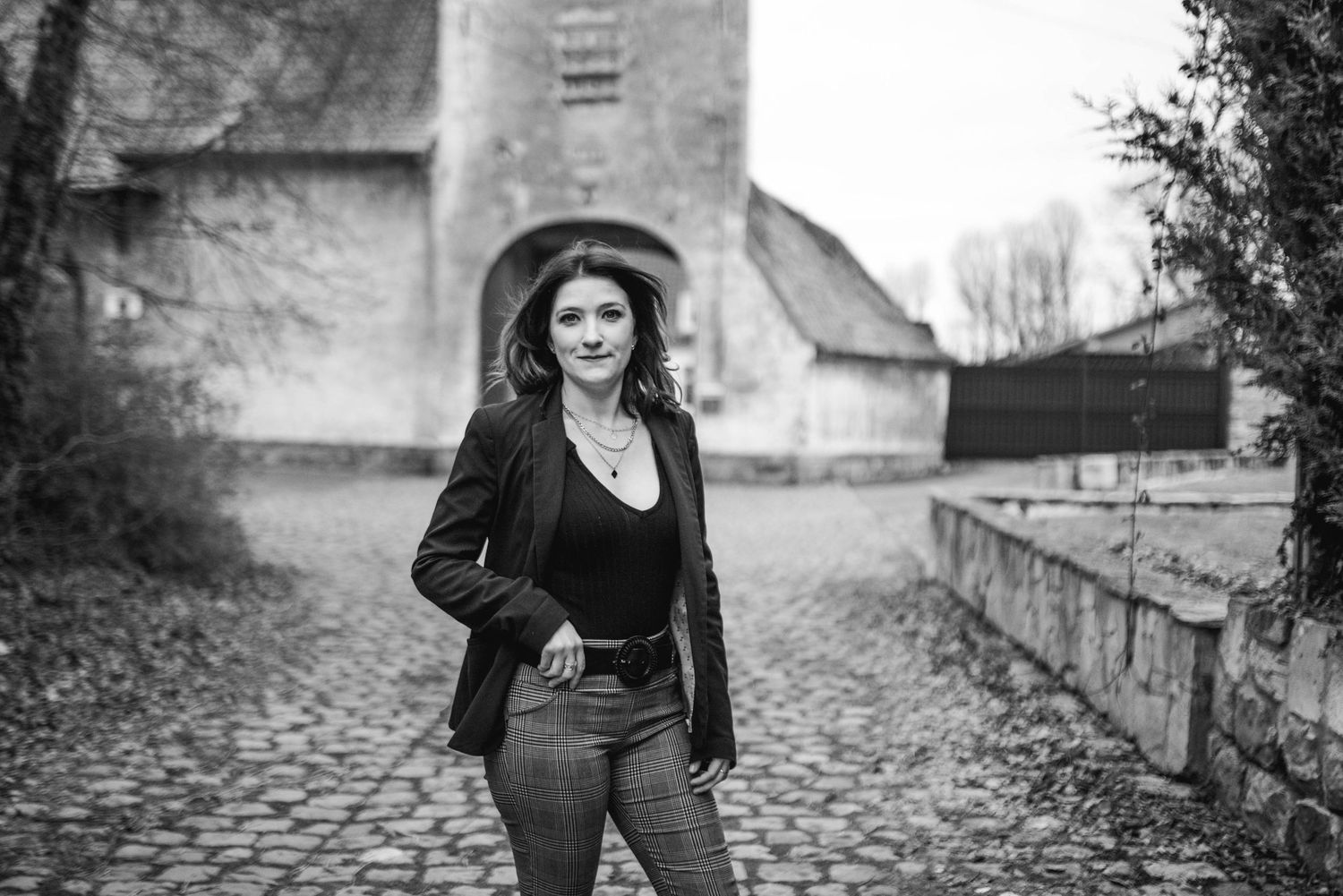 Urban portrait session featuring architectural elements and stone walls.