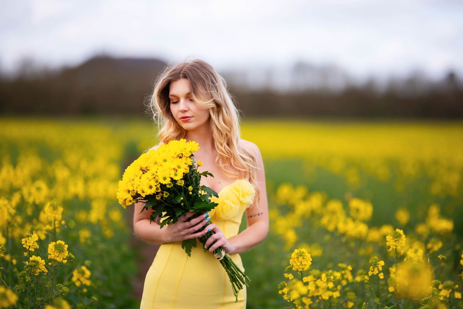 Spring portrait session in a vibrant field of yellow wildflowers.