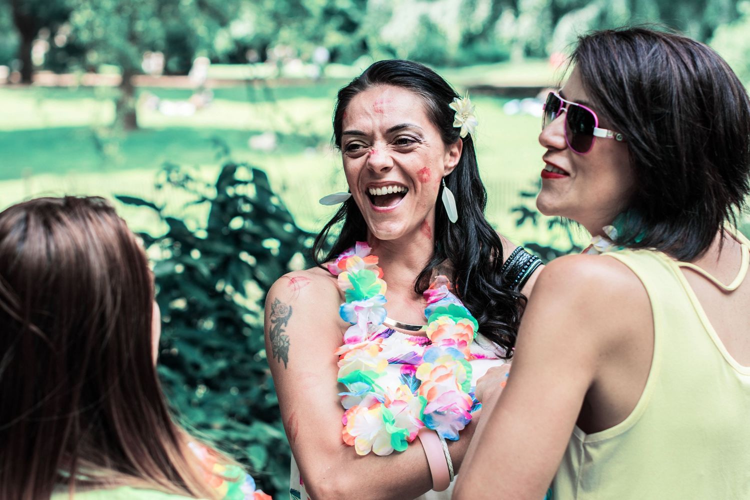 Friends posing playfully in a garden setting wearing colorful summer outfits.