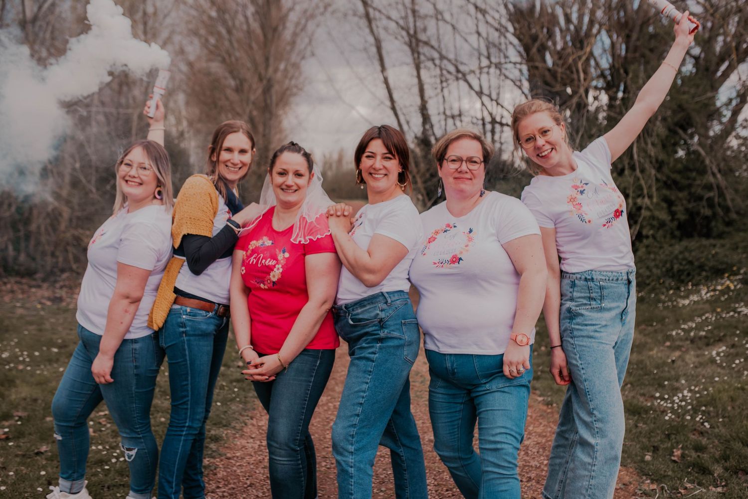 Friends posing together in casual denim outfits during an outdoor photoshoot.
