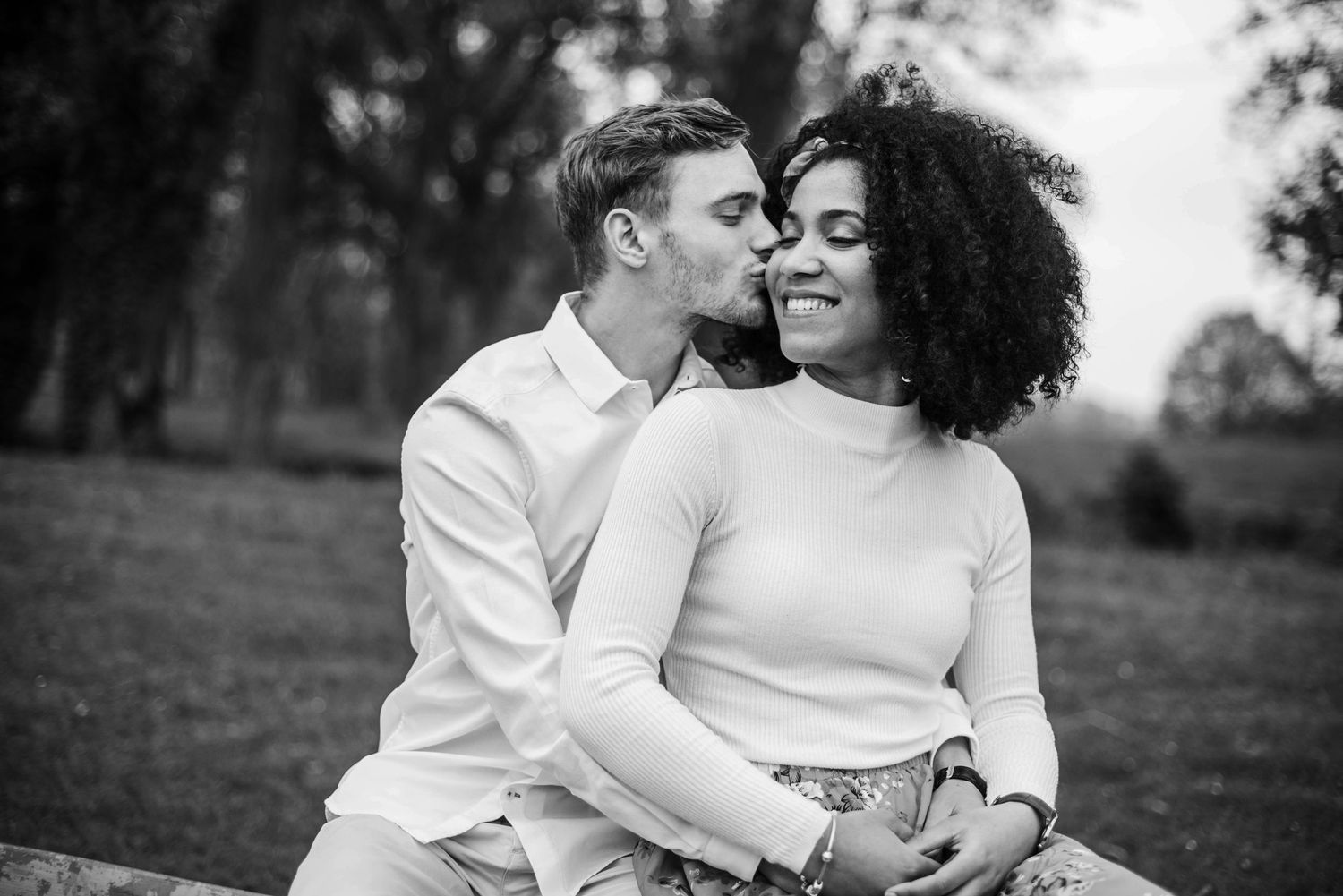 Intimate black and white portrait of couple embracing outdoors.