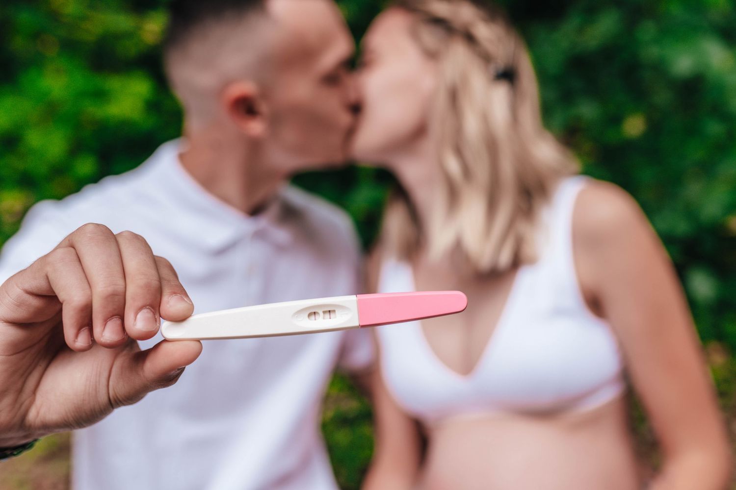 Close-up shots showing hands holding a pregnancy test in an outdoor setting.