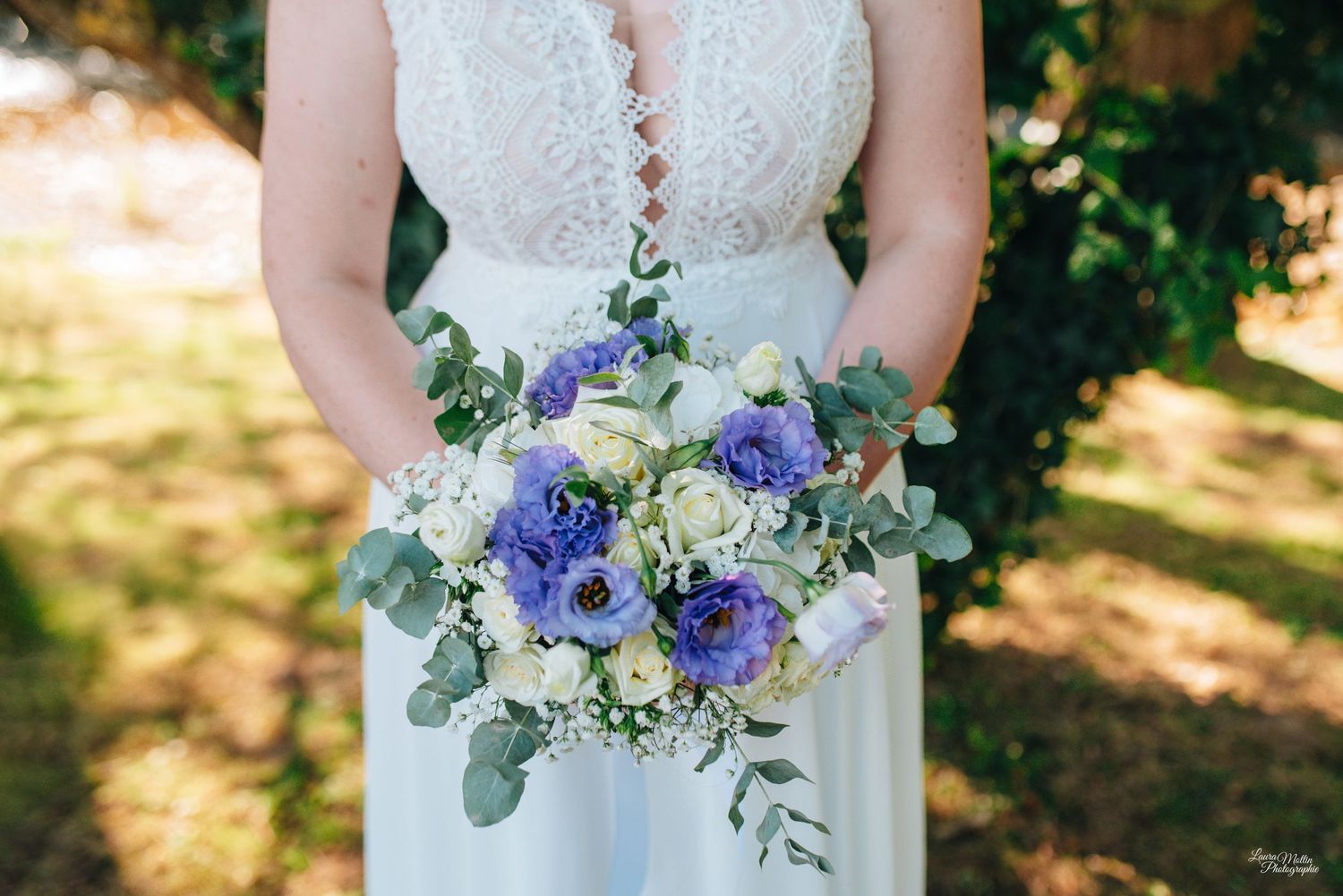 Elegant bridal bouquet featuring blue and white flowers with eucalyptus leaves.