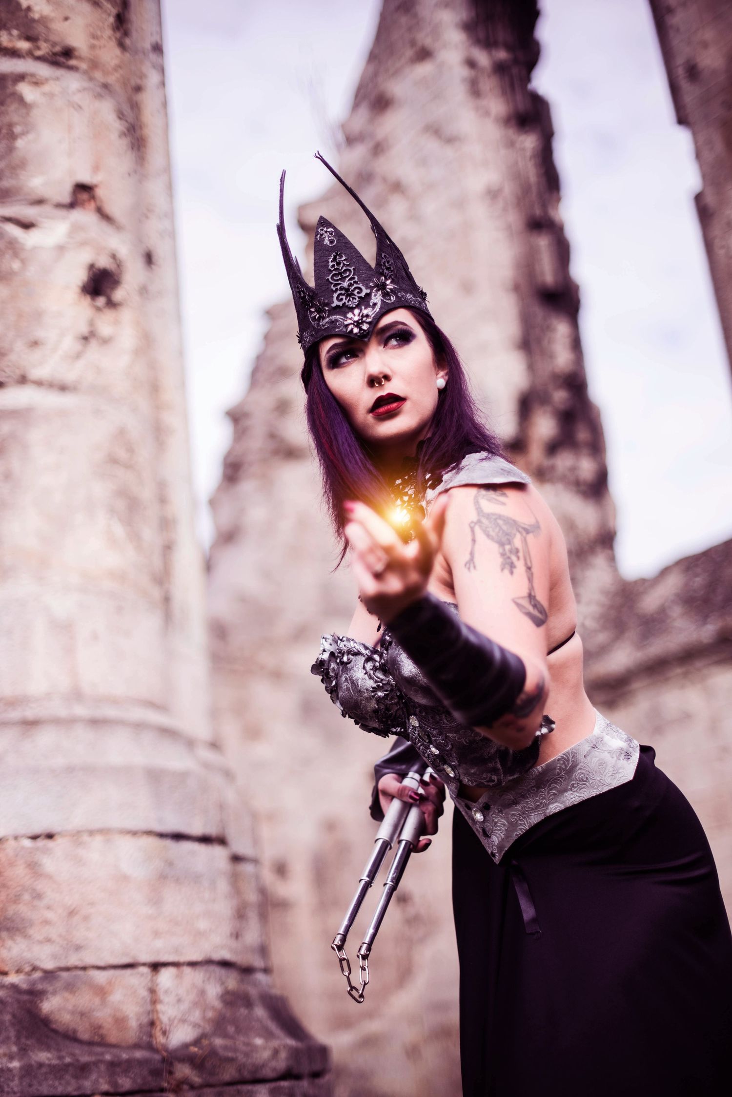 Gothic fashion photography in stone ruins with dramatic lighting effects.