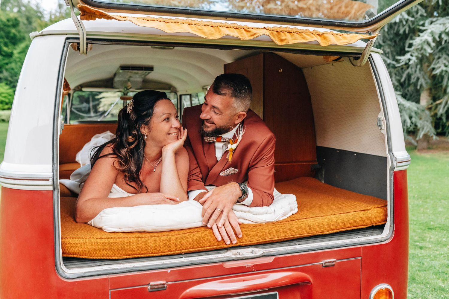 Newlyweds sharing intimate moments inside a vintage red and white van.