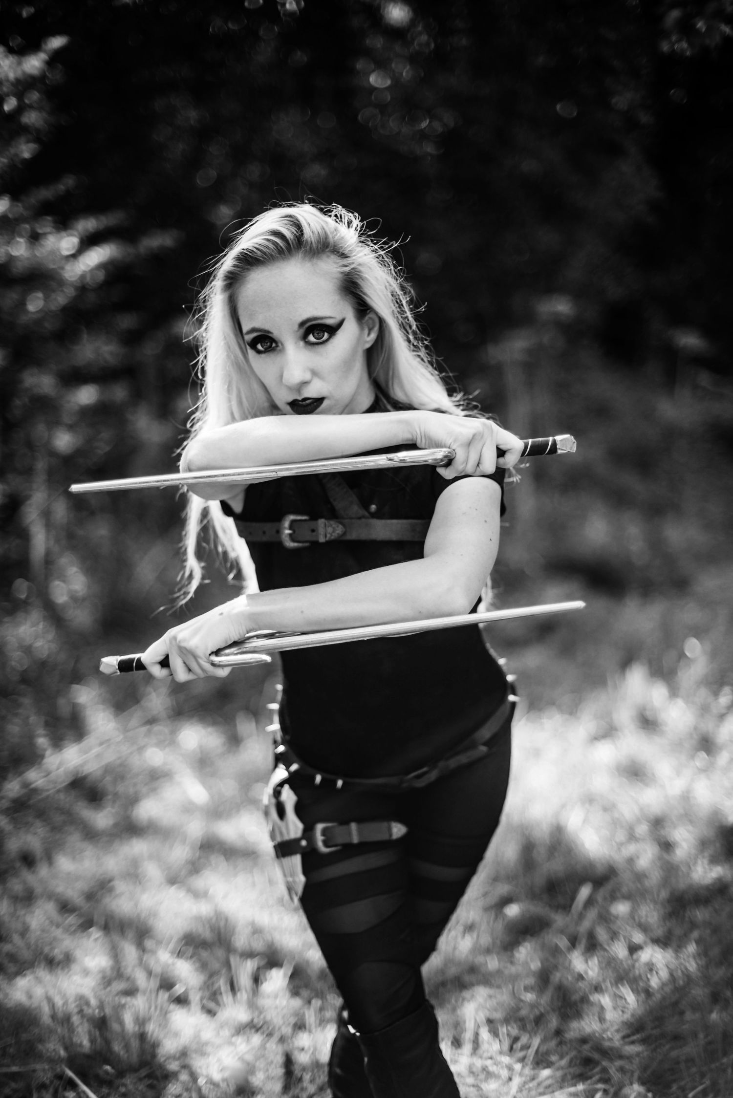 Dramatic black and white portraits featuring sword poses against a natural backdrop.