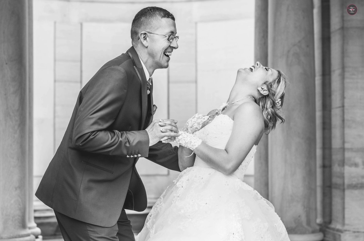 Classic black and white wedding photo captured against architectural columns.