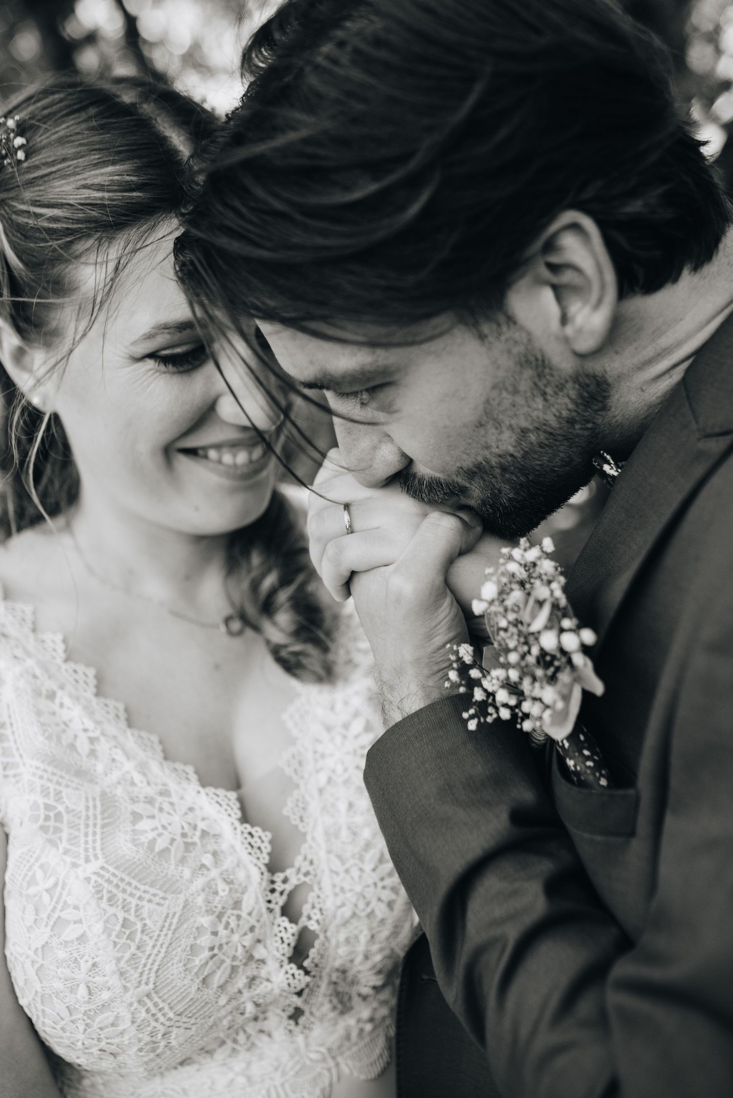Intimate black and white portrait of couple in wedding attire with lace details.