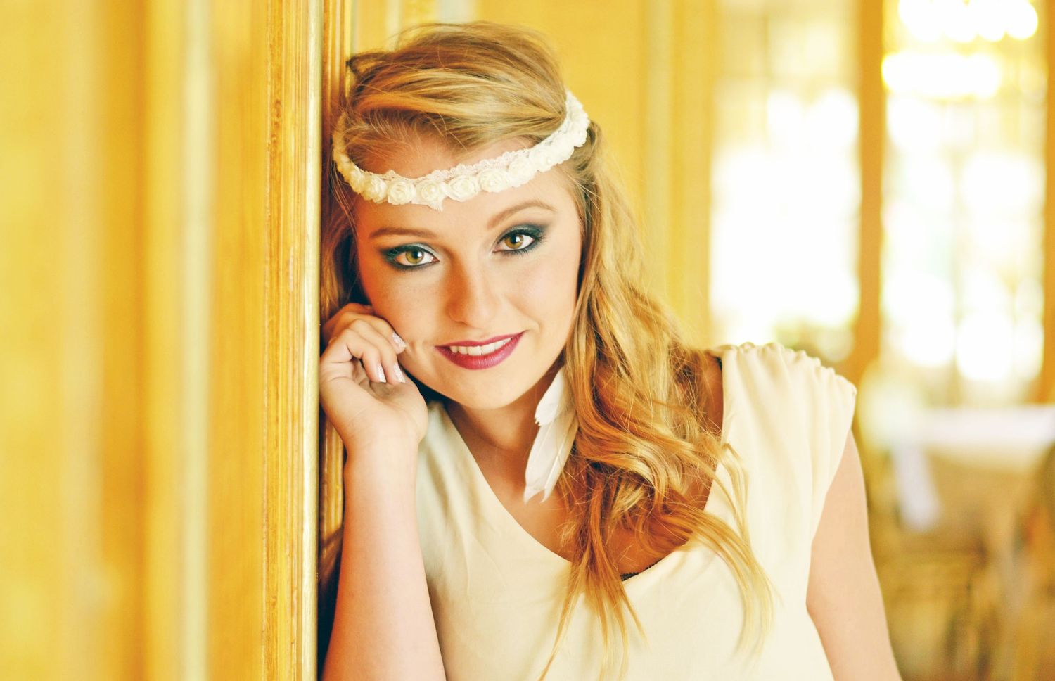 Vintage-inspired portrait with soft yellow lighting and delicate headpiece.