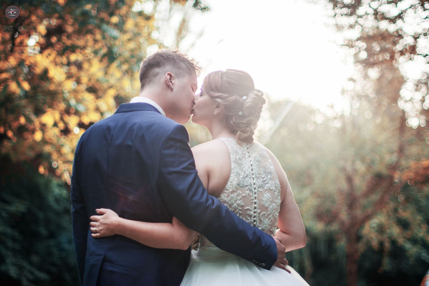 Couple sharing an intimate moment during sunset in an autumn setting.