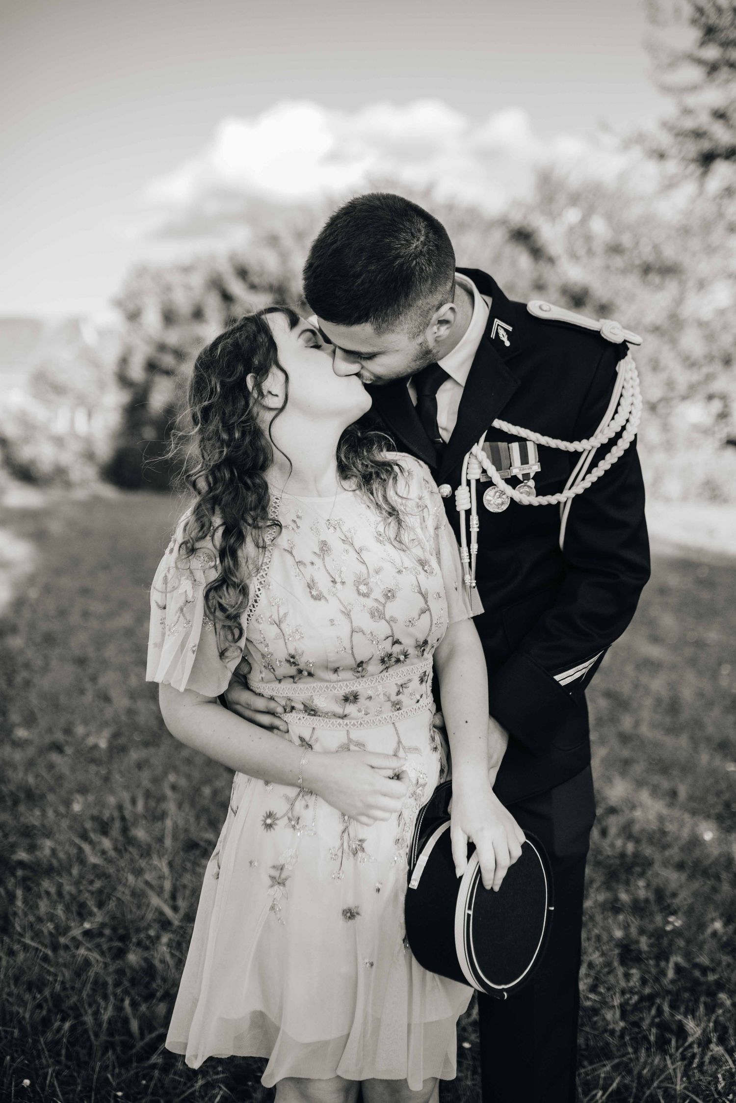 Black and white portrait series of a couple in formal attire sharing romantic moments outdoors.