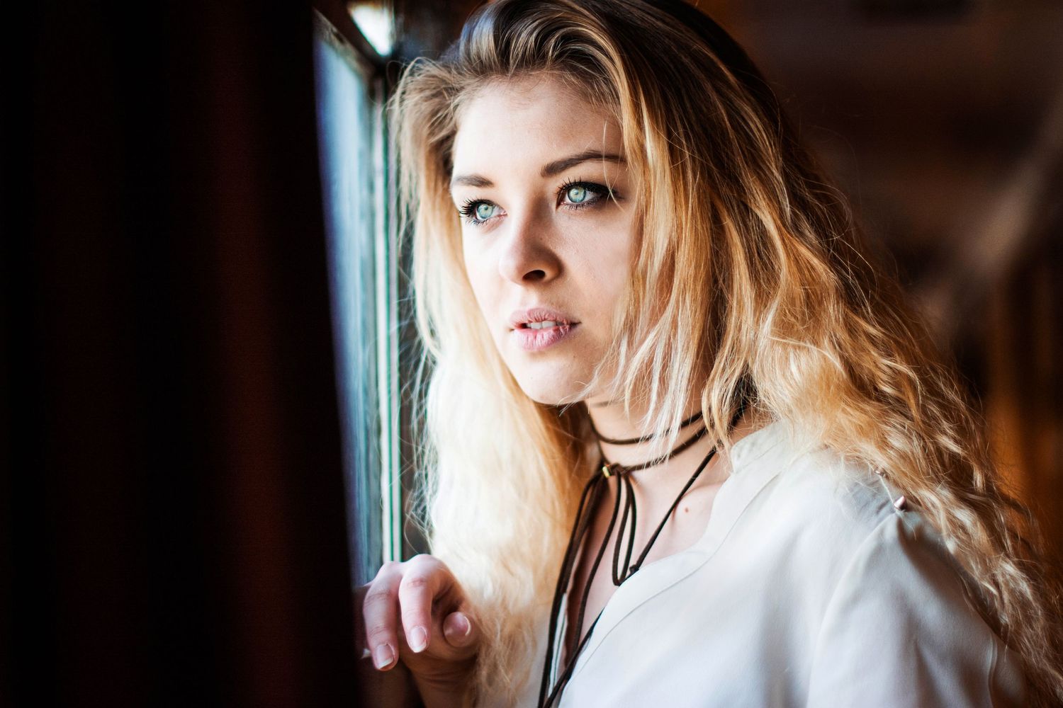 Artistic portrait with dark background and dramatic lighting.