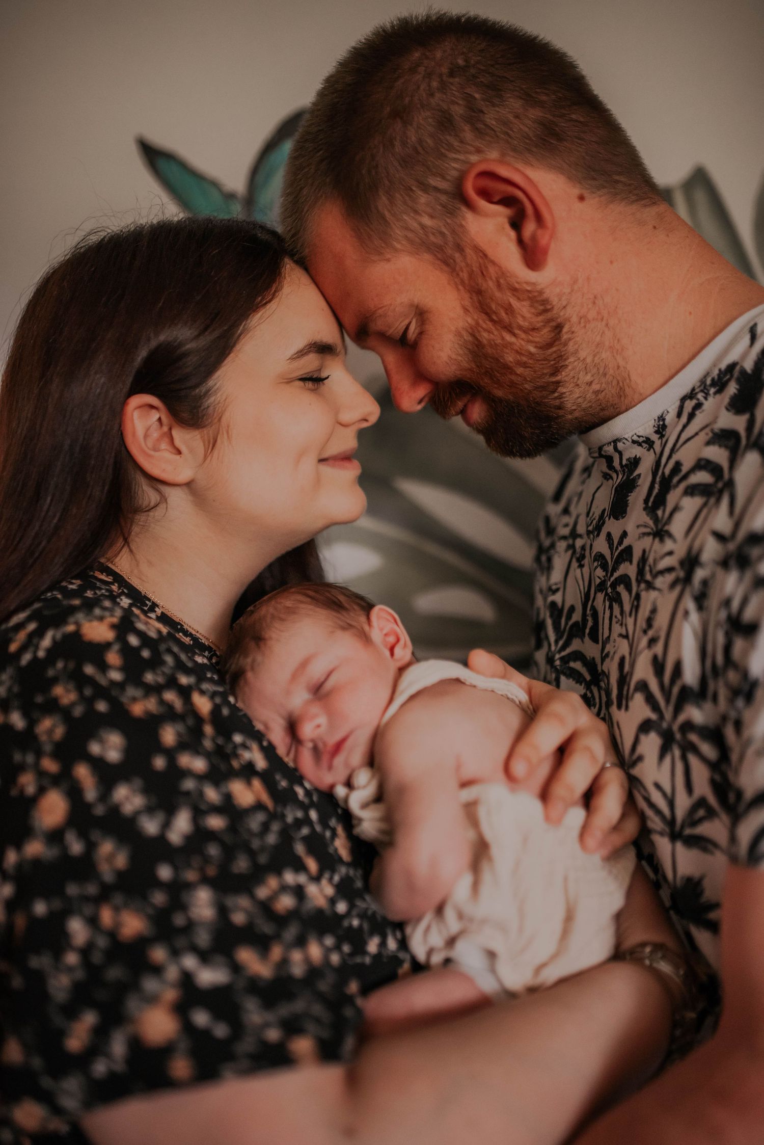 Tender family moments captured in moody lighting with floral and geometric patterns.