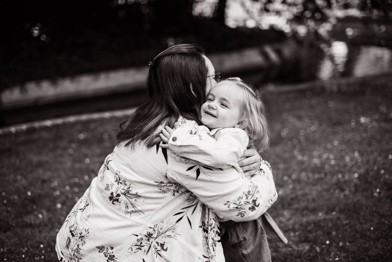 Black and white portrait of two people embracing and sharing a tender moment.