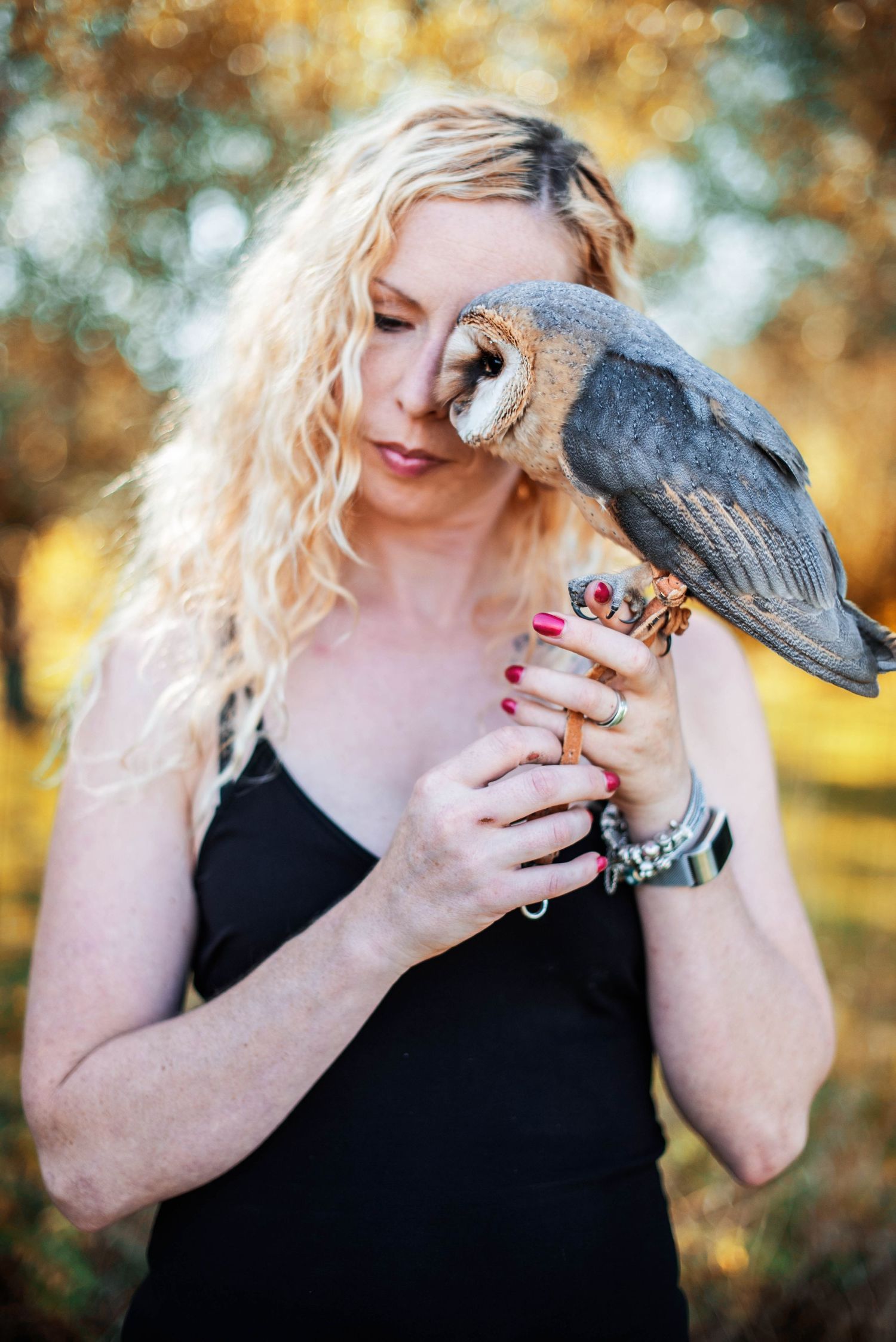 Intimate portrait series with pet crow against warm autumn bokeh background.
