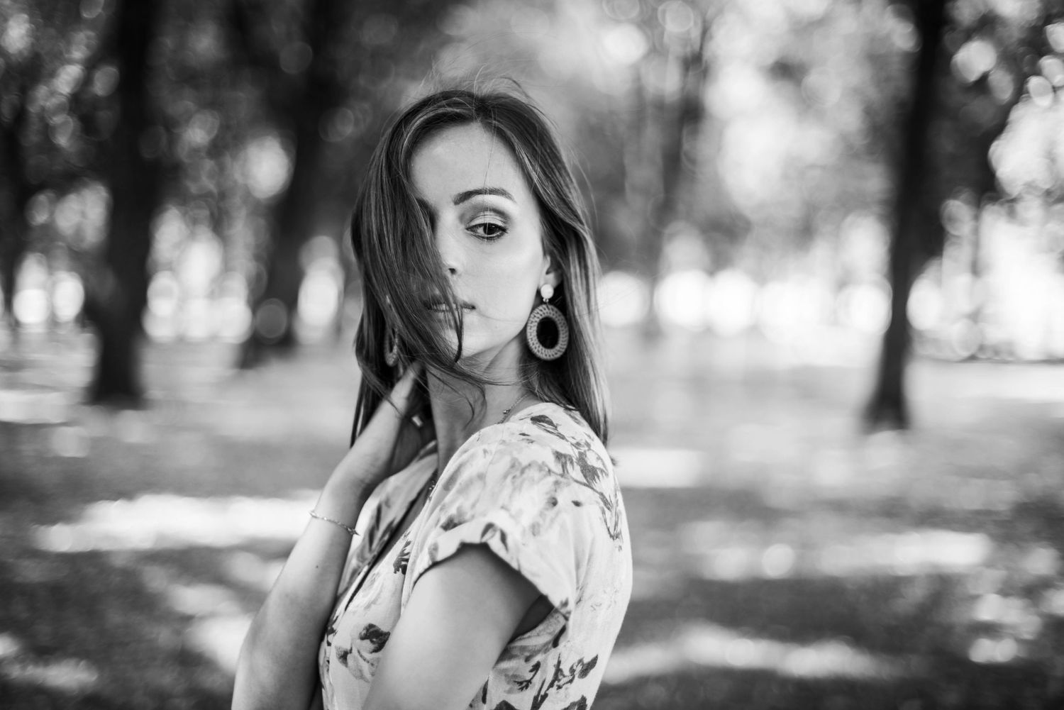 Outdoor fashion portraits in floral dress captured in natural park setting.