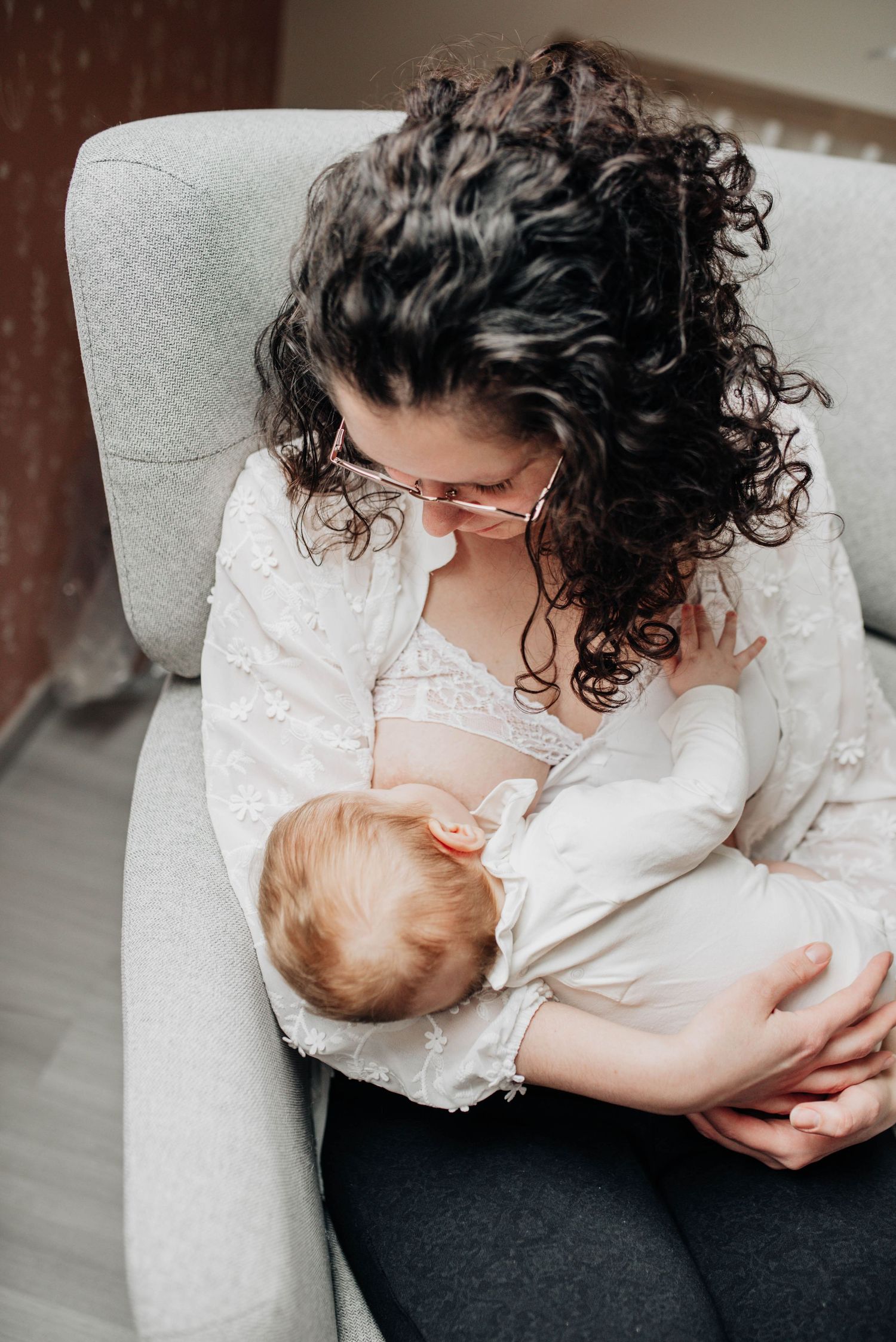 An intimate series showing nursing moments on a gray couch.