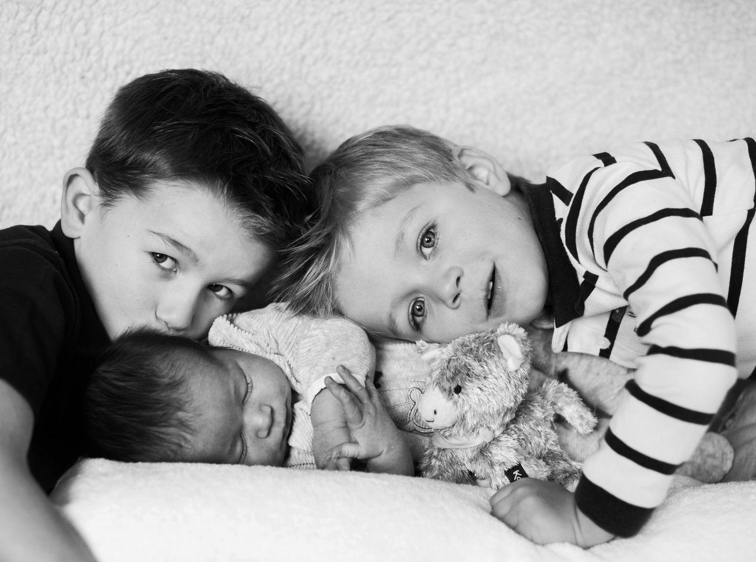 Series of black and white photos showing sleeping baby with stuffed animal.
