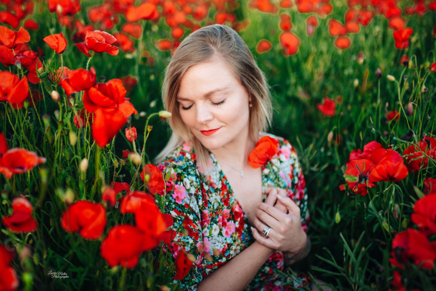 Portrait in field of vibrant red poppies with soft natural lighting.