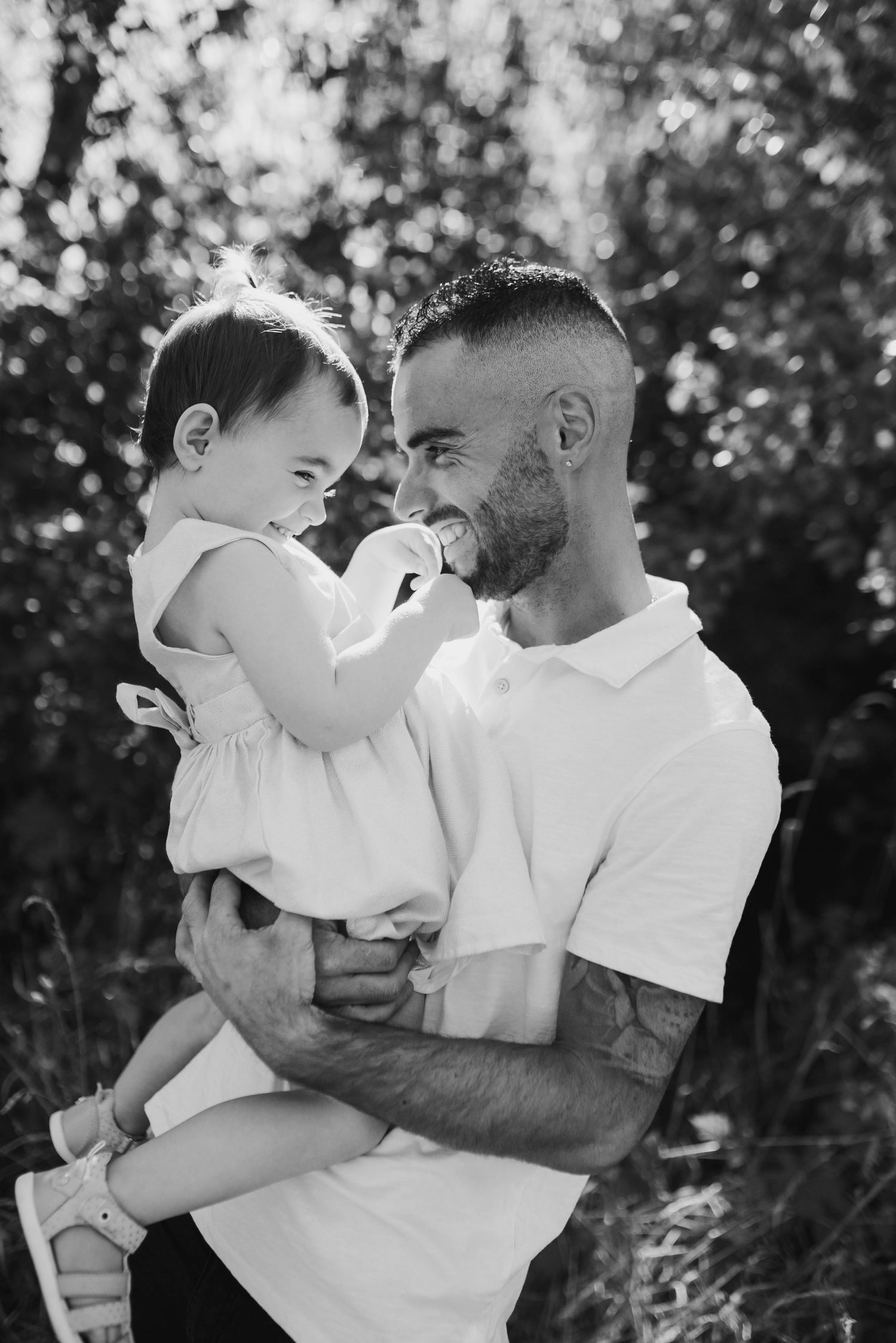 Tender black and white photo series showing parent and child sharing intimate moments outdoors.