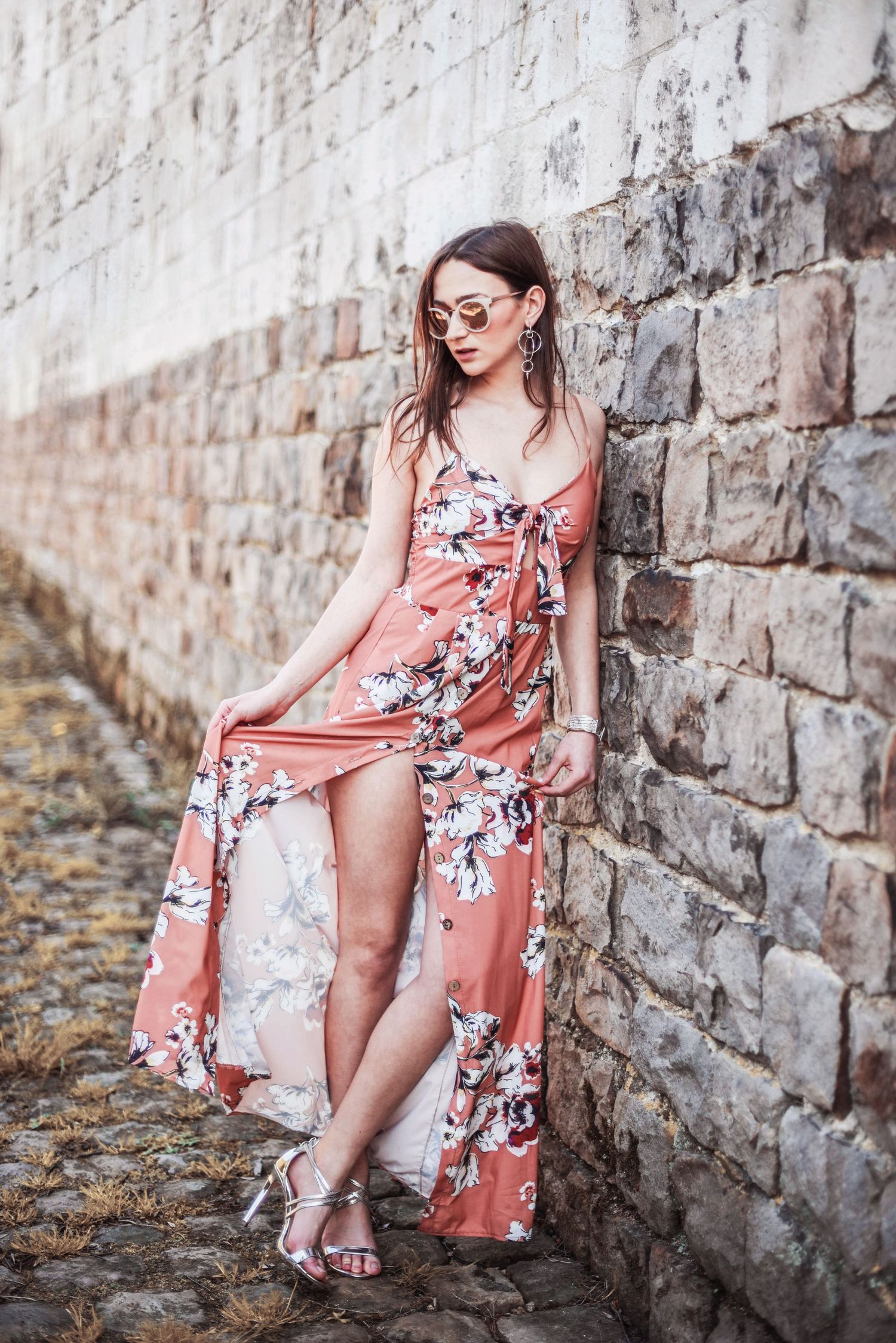 Romantic fashion shoot featuring coral floral kimono against stone wall backdrop.