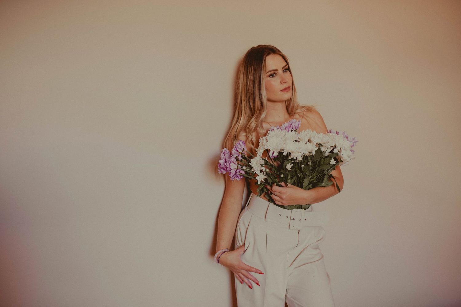 Soft minimalist portraits with white flowers against a neutral background.
