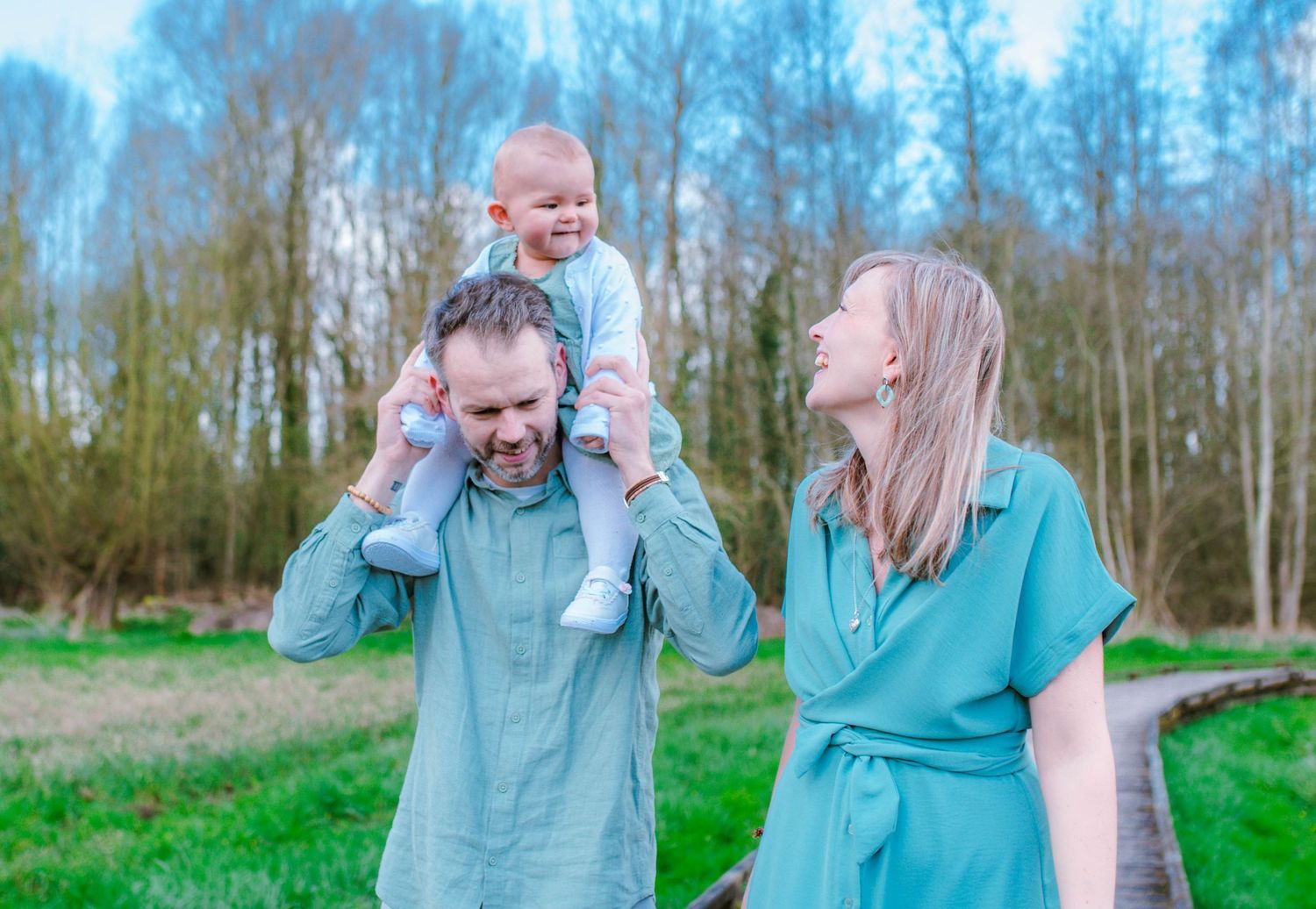 Family photo session in a spring forest with soft natural lighting.