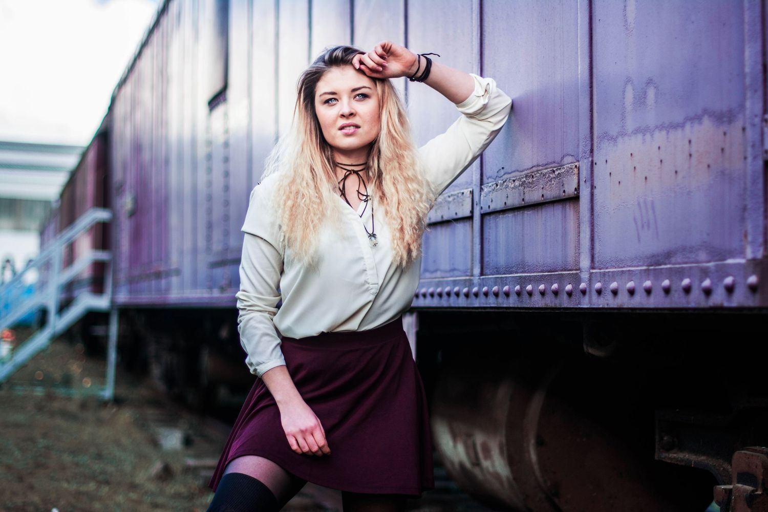 Moody portrait session against industrial purple metal background.