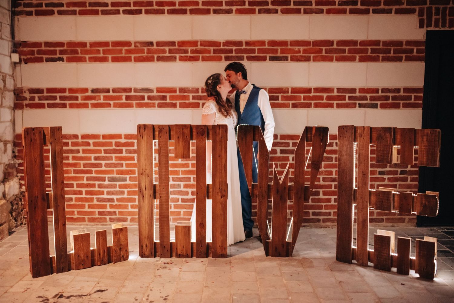 Wedding venue exterior featuring rustic red brick walls and wooden beams.