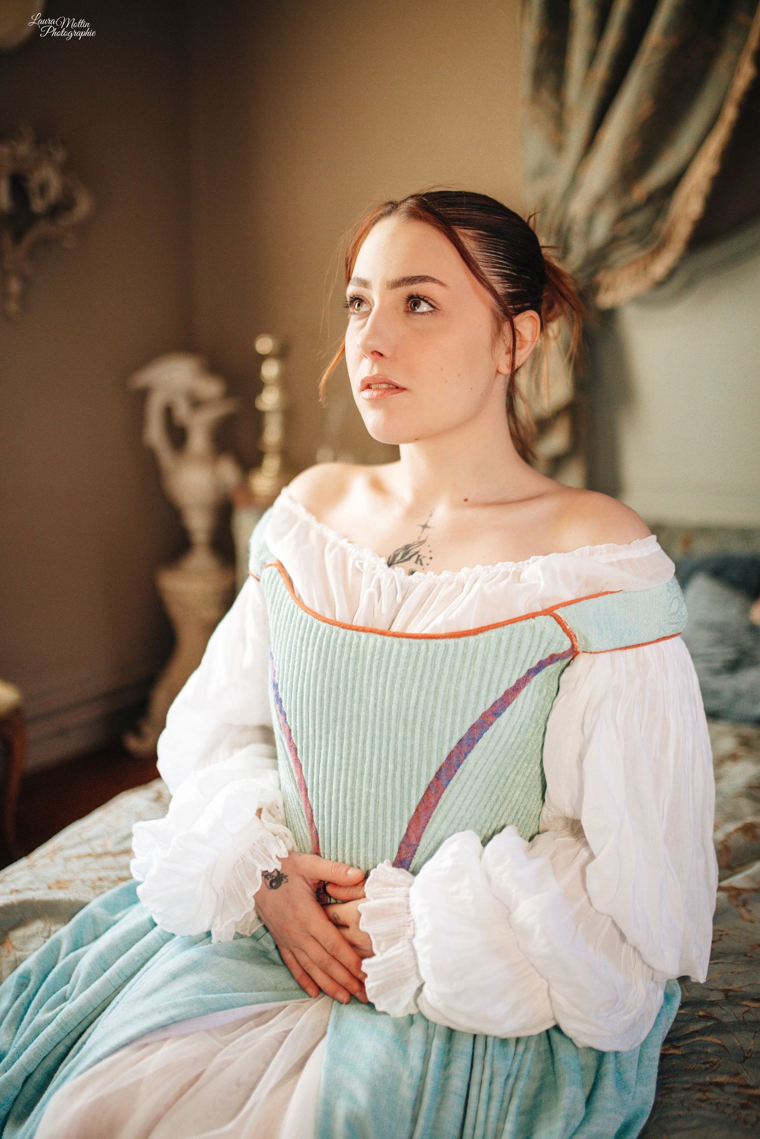 Period costume portrait featuring light blue and white dress with ruffled collar in soft natural lighting.