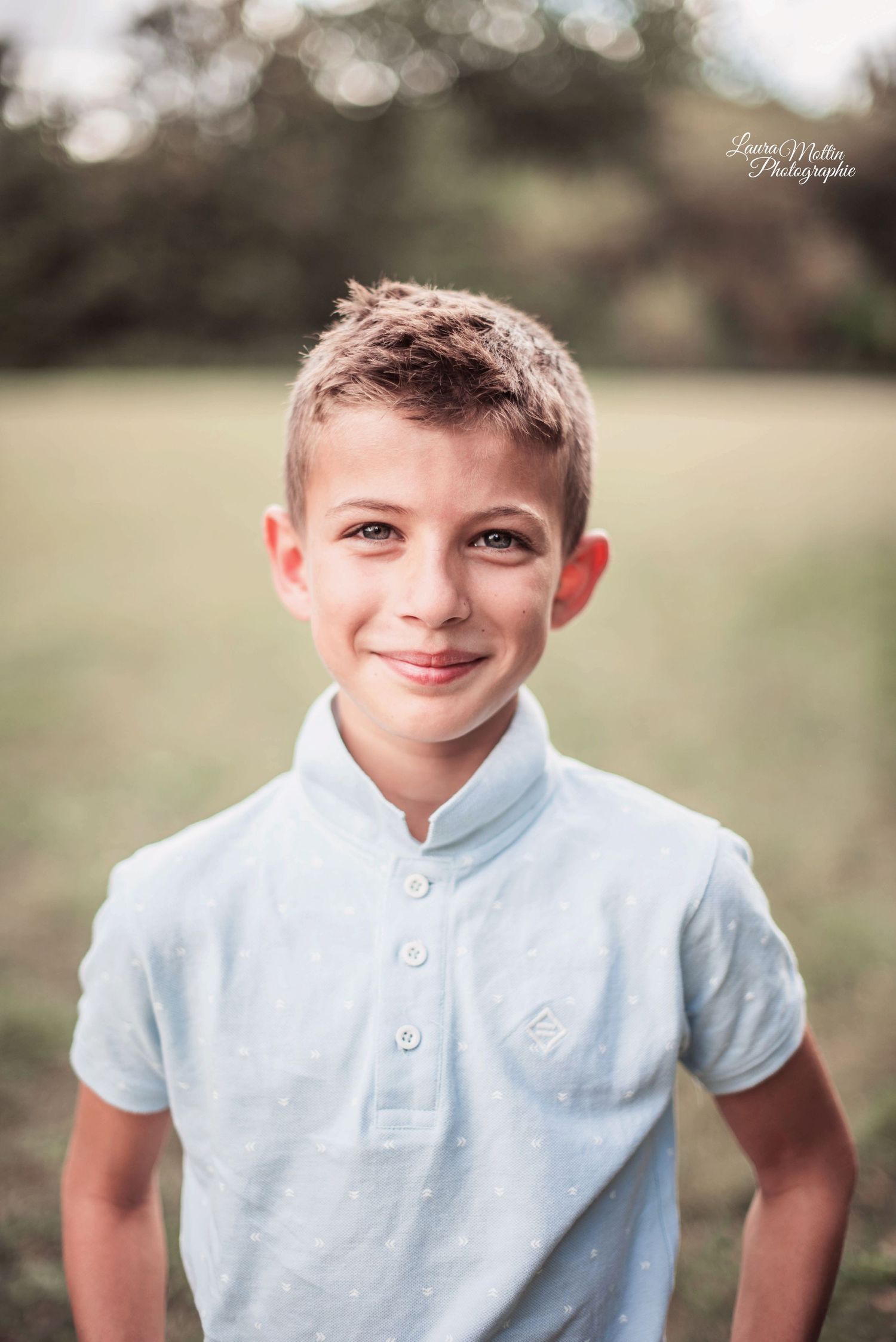 Casual outdoor portrait series in light blue polo shirt against blurred natural background.