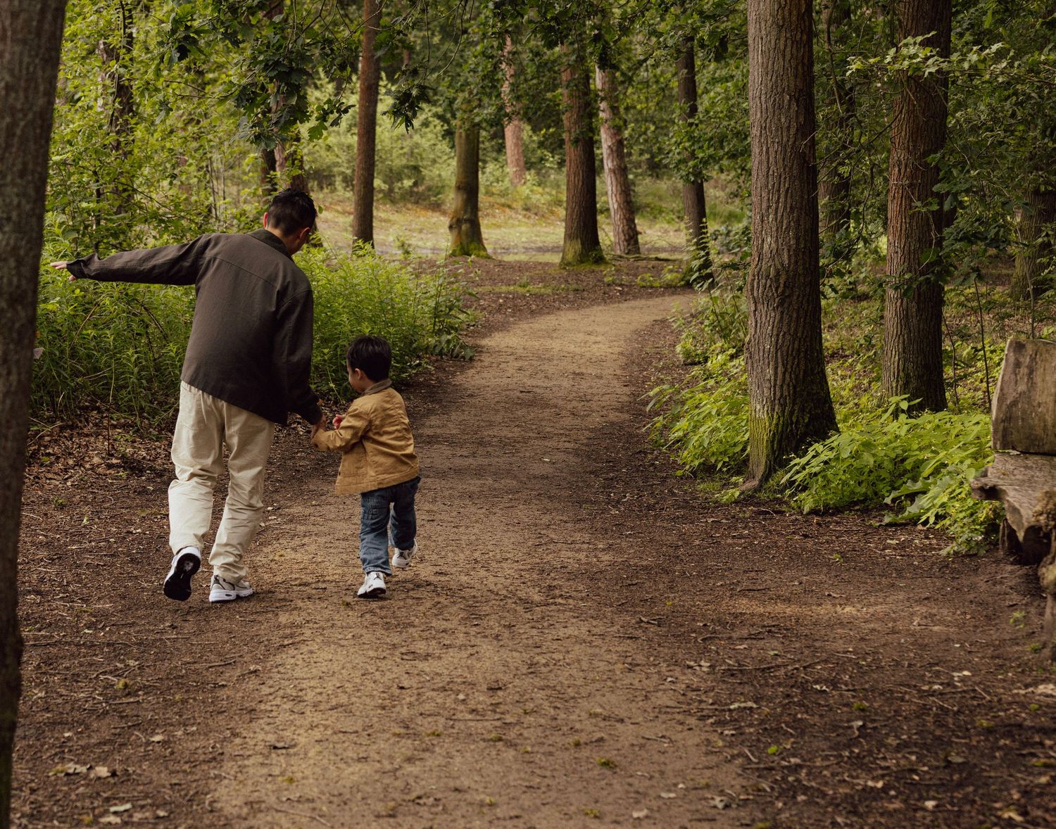 A happy family walking together along a forest path during a relaxed lifestyle photoshoot in Eindhoven.