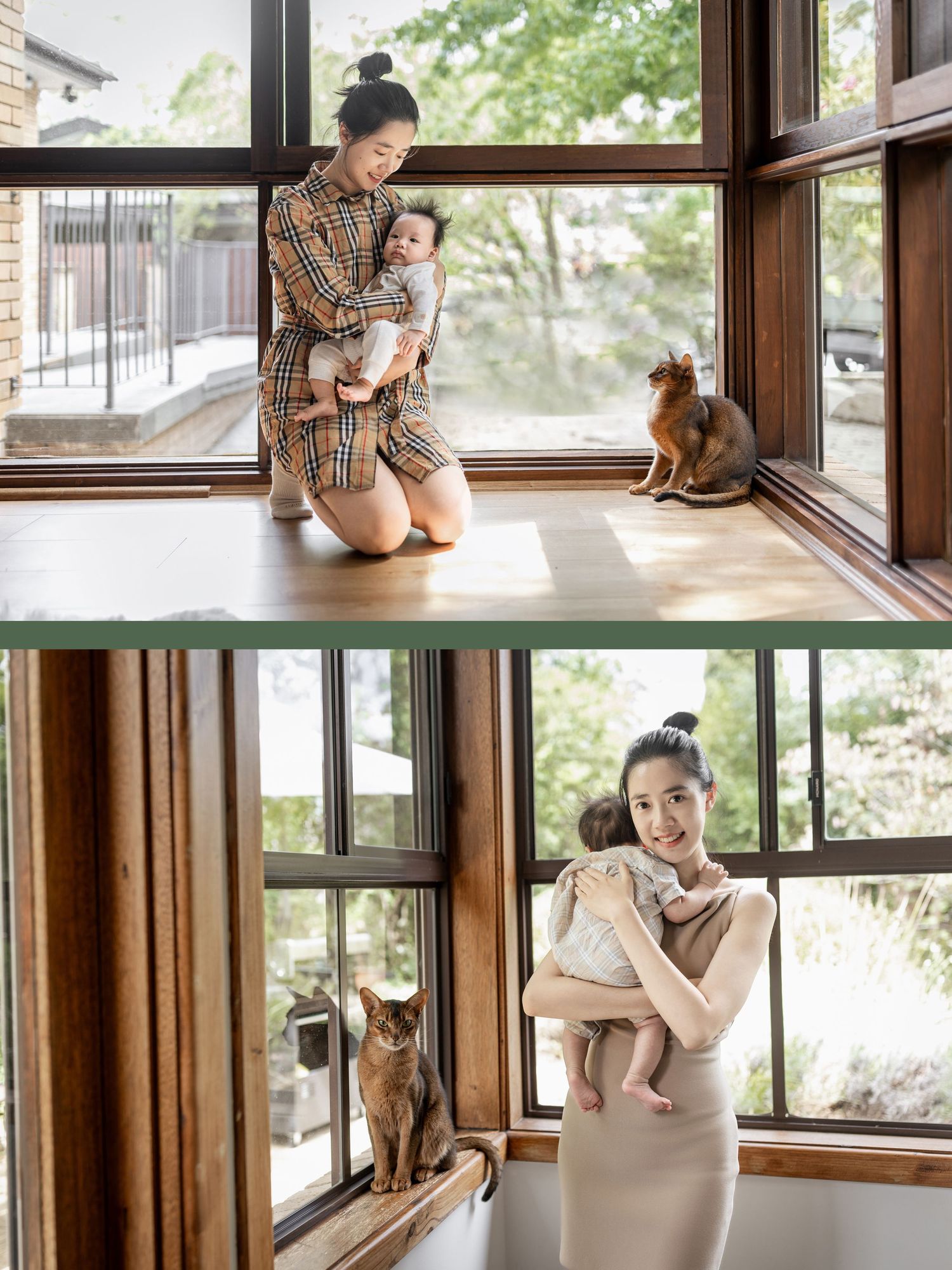 A mother kneels on the floor holding her baby near large wooden windows with two cats nearby.