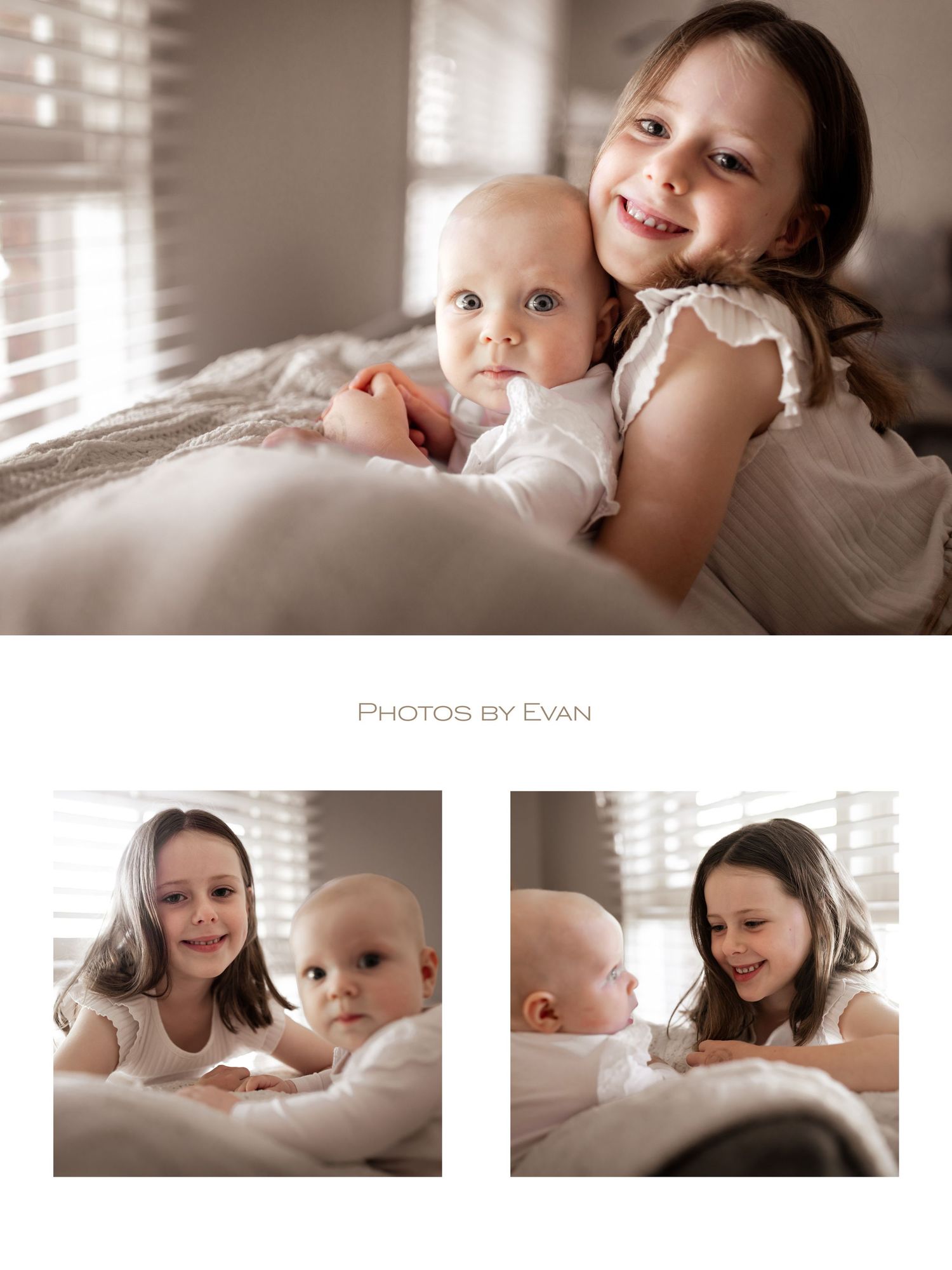An older sister hugs and smiles with her baby sibling on a soft white bed indoors.