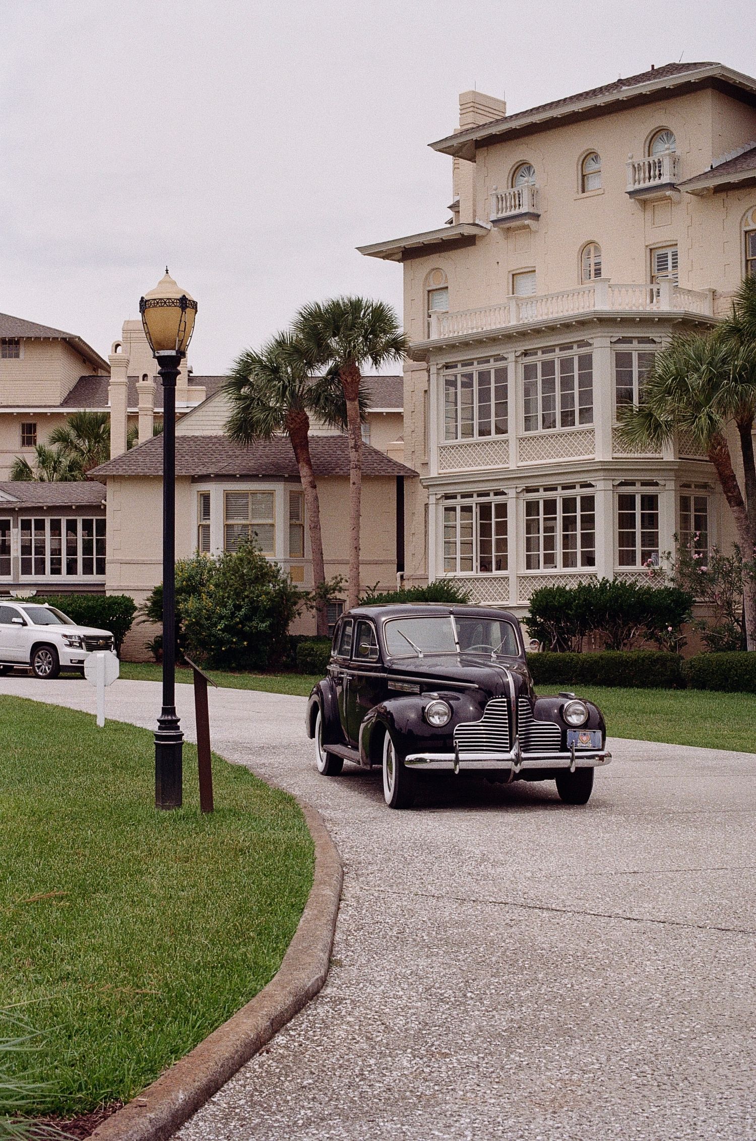 old vintage car in front of old vintage hotel