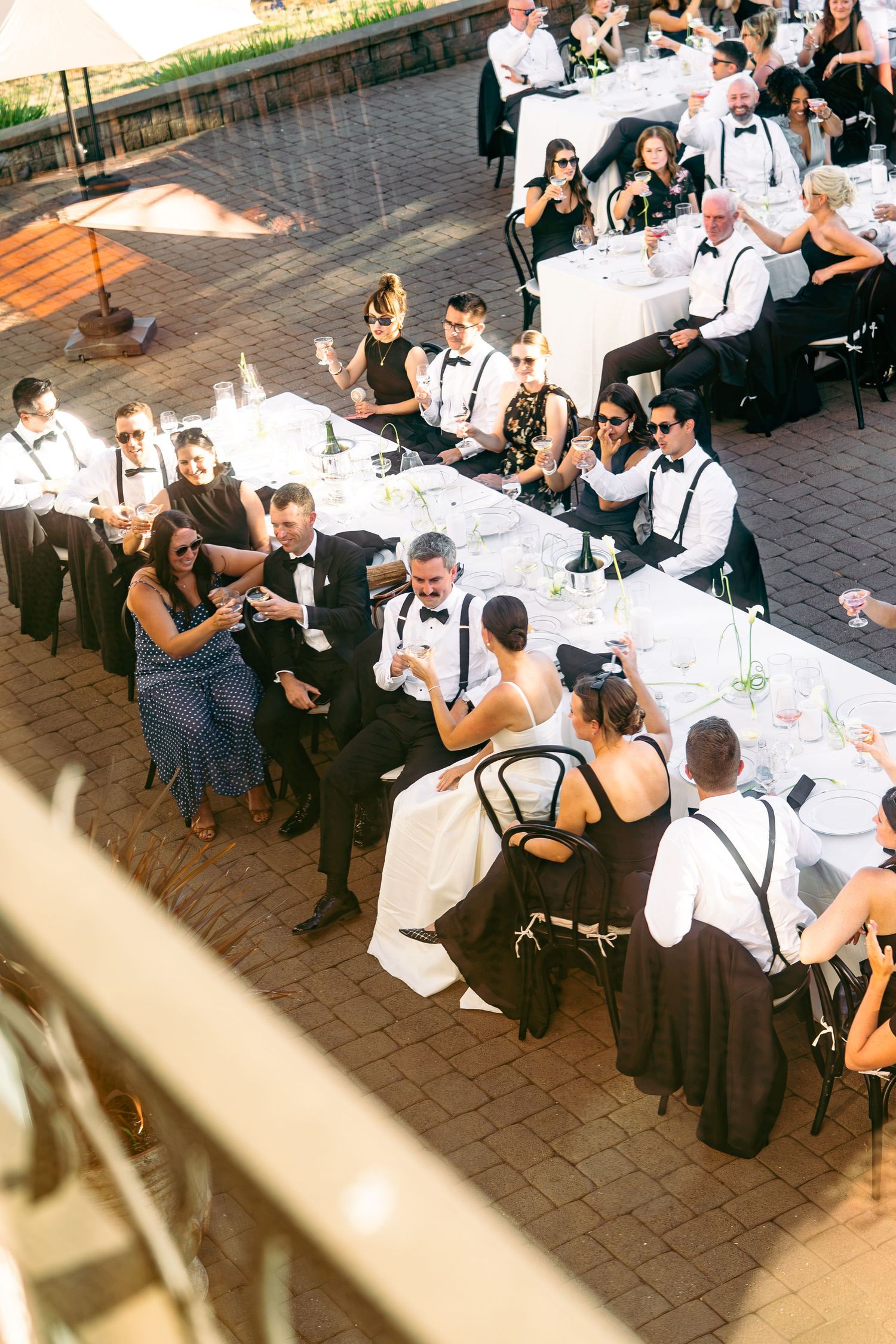 couple holding glasses toasting with other guests