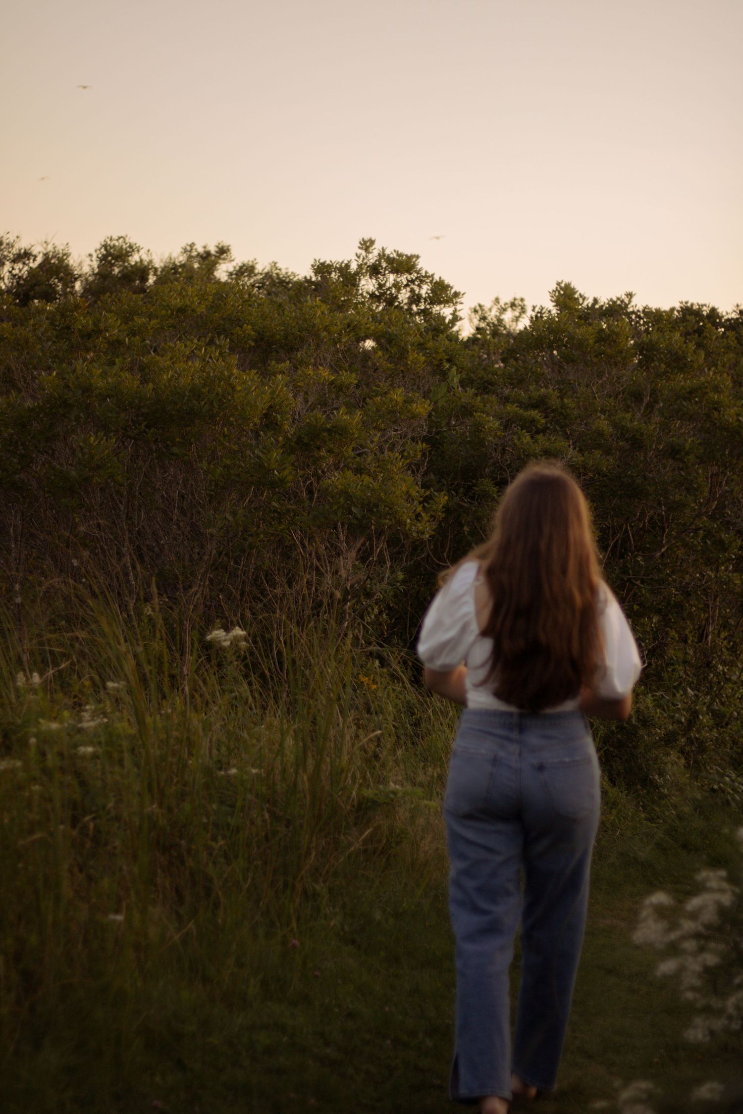 girl in field walking away
