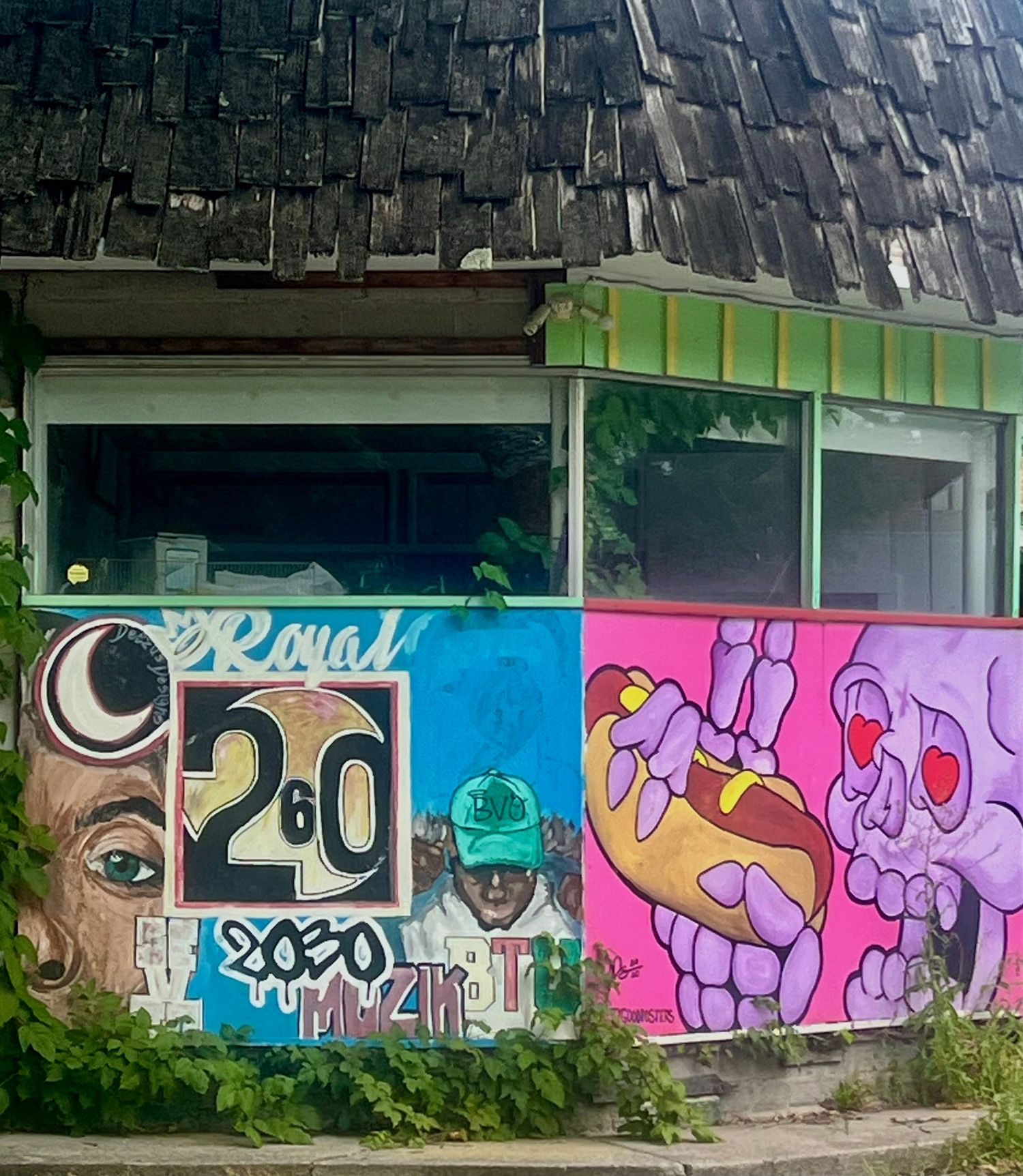 Colorful graffiti mural with bold numbers, cartoon characters, and street art on an abandoned building wall.