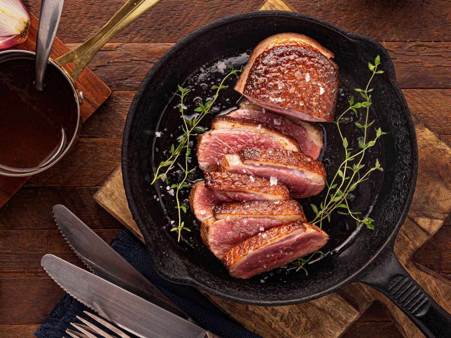 Overhead shot of roasted duck breast in a cast iron pan